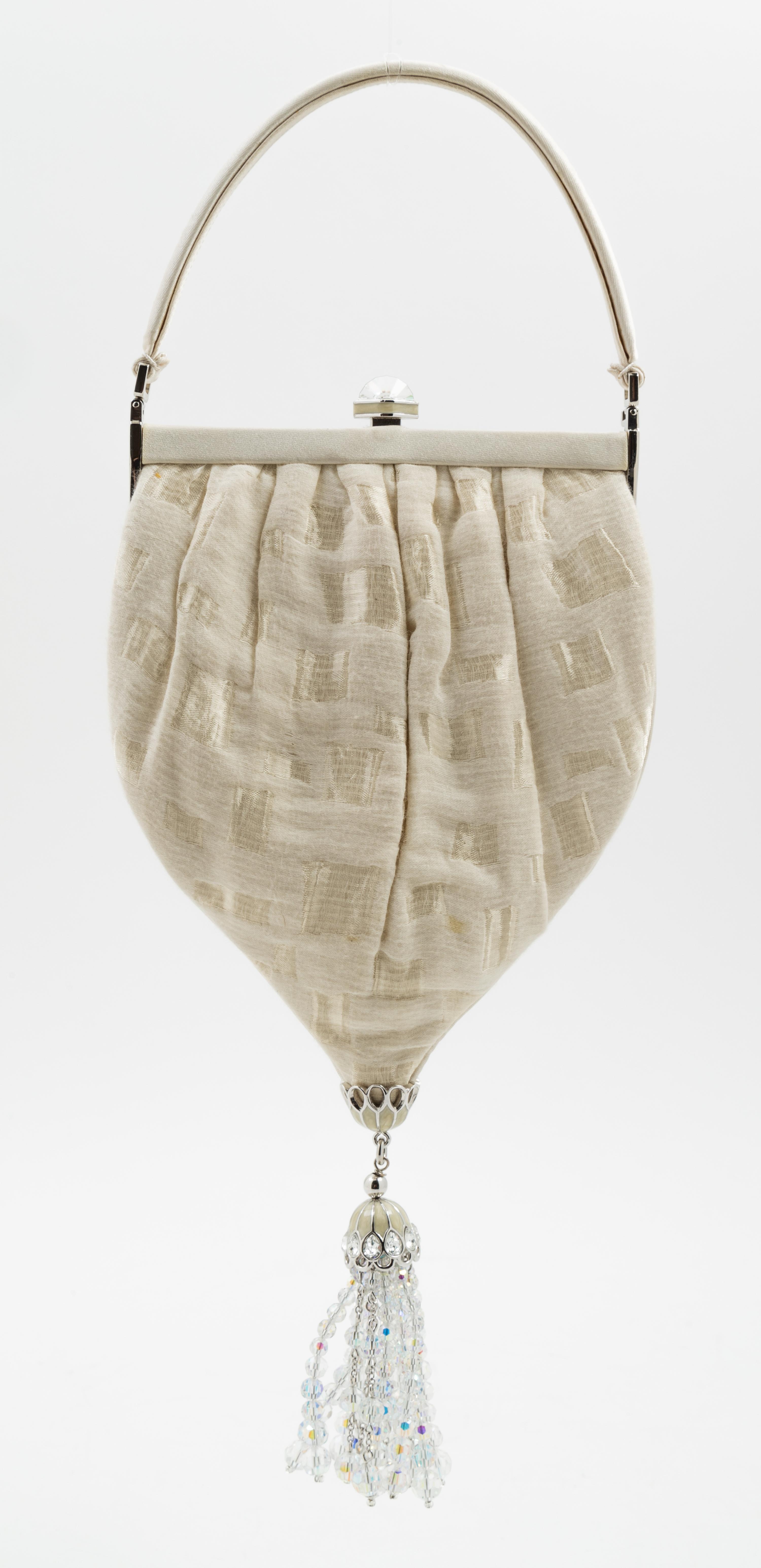 A Judith Leiber Cream Silk Textured Handbag, 5.5" x 10" x 1"; Handle drop: 3".