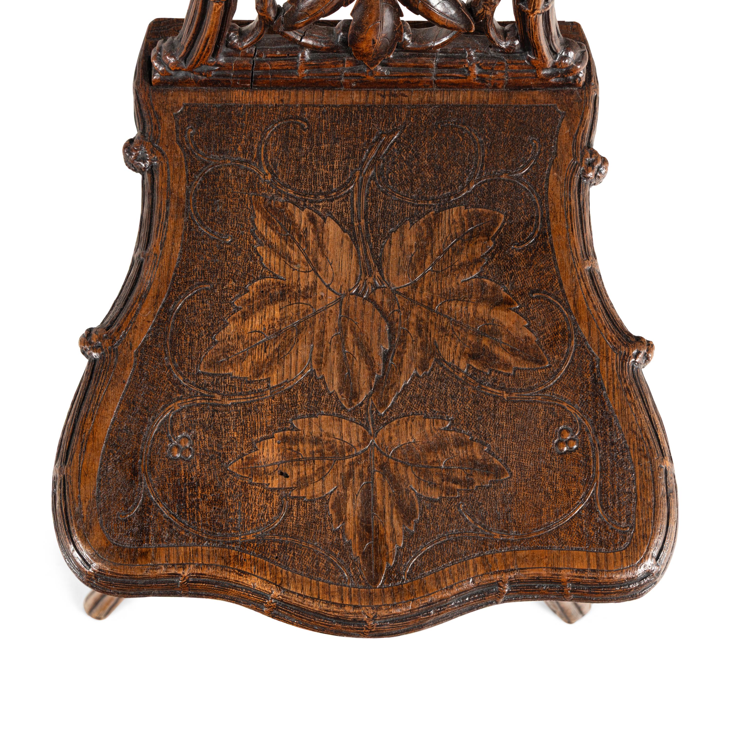 A Pair of Black Forest Oak Leaf Carved Side Chairs