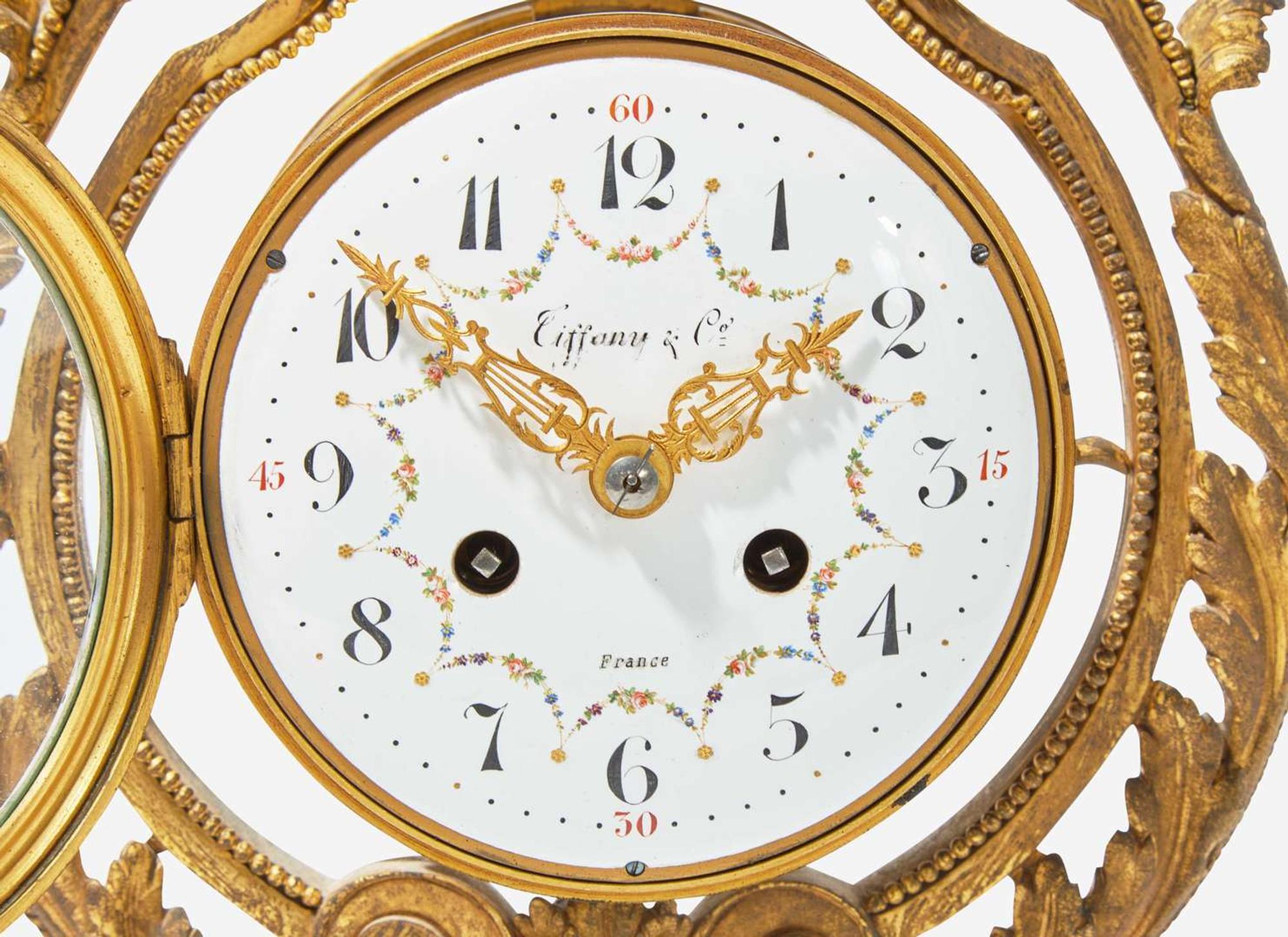 A French Louis XVI style three-piece gilt bronze and white marble clock garniture, retailed by Tiffany & Co., New York, NY, late 19th century