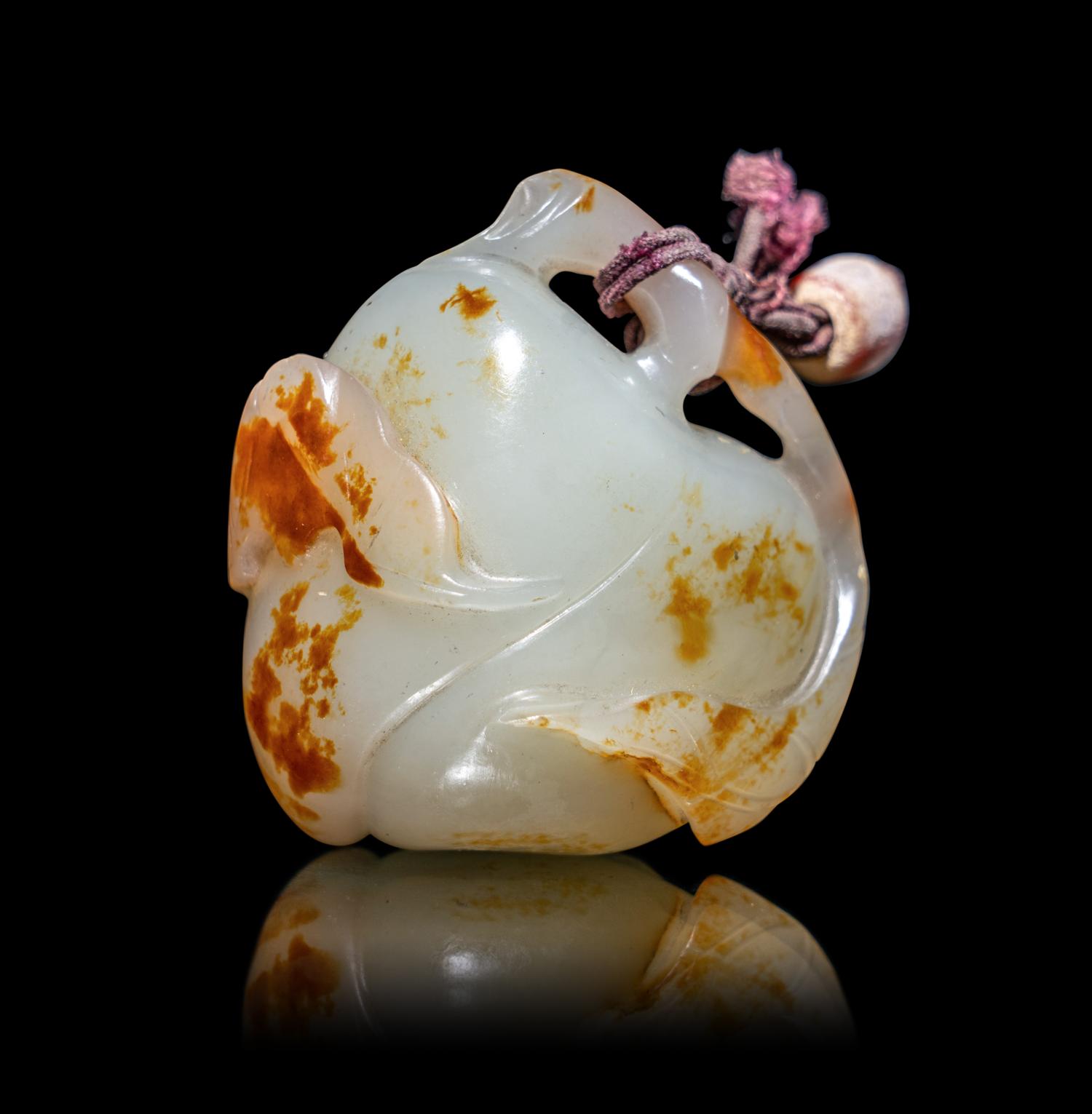 A Chinese Russet and White Jade 'Peach and Bat' Pendant
