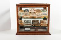 A Collection of Fifteen Tobacco Cartons and a Tobacco Rope in Display Case