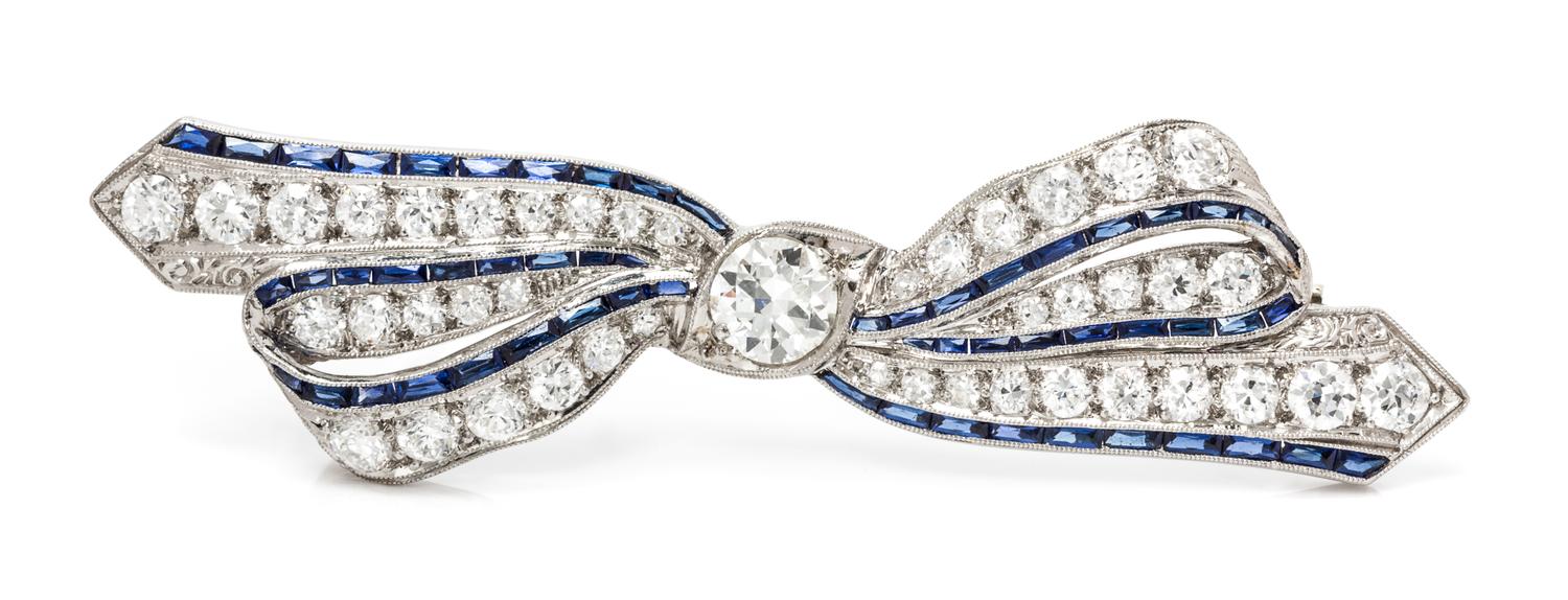 An Art Deco Platinum, Diamond and Synthetic Sapphire Bow Brooch, 5.20 dwts.