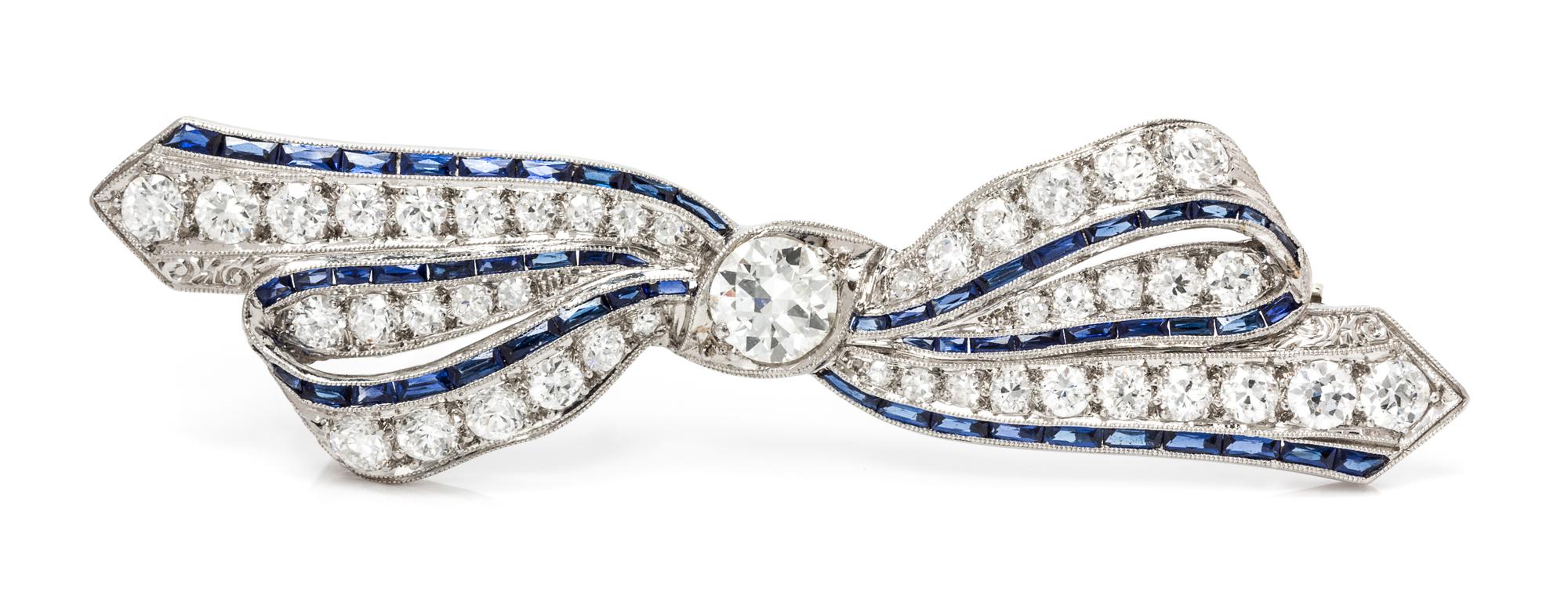 An Art Deco Platinum, Diamond and Synthetic Sapphire Bow Brooch, 5.20 dwts.