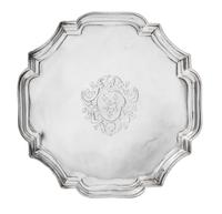 A George I Silver Salver, John Tuite, London, 1727, the piecrust rim centered by an engraved shield crest and raised on four volute fee