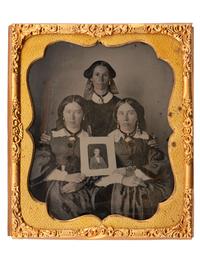 [LINCOLNIANA - EARLY PHOTOGRAPHY]. Sixth plate ambrotype of three patriotic women proudly displaying a portrait of Abraham Lincoln.