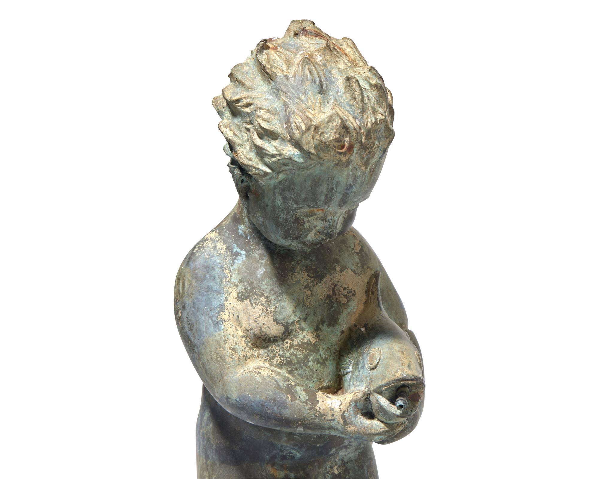 A cast zinc fountain head of a boy holding fish, 20th century