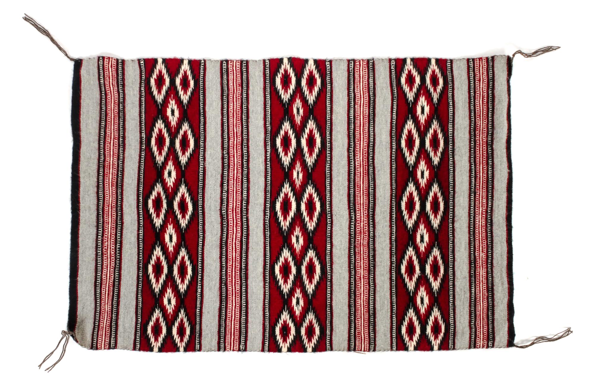A Navajo Yei Rug First: 33 x 21 inches.