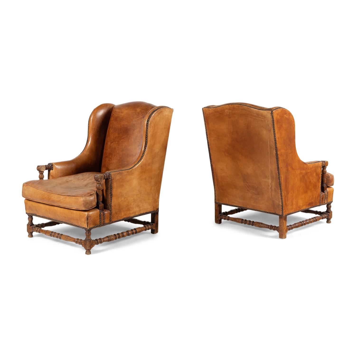 A Pair of Louis XIII Style Oak and Leather Wingback Armchairs