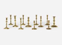 A group of twelve Chippendale octagonal or notched base brass candlesticks, England, late 18th century