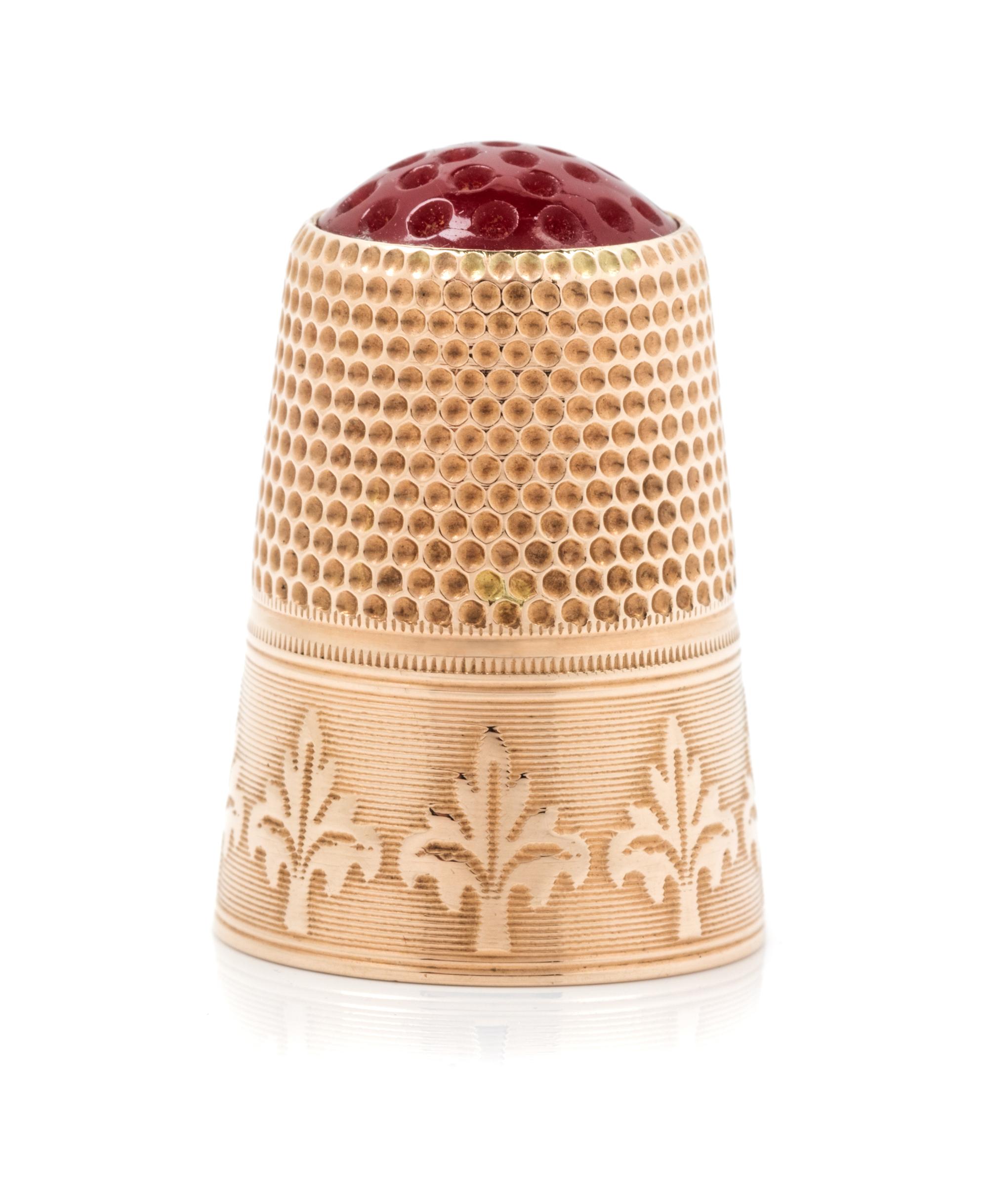 A Continental 12-Karat Gold and Hardstone Thimble, , the hardstone top and knurled body above a foliate decorated band on an engine tur