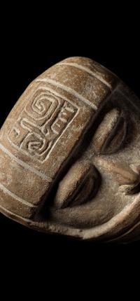 A Veracruz Terracotta Head Wearing a Helmet with an Incised Glyph