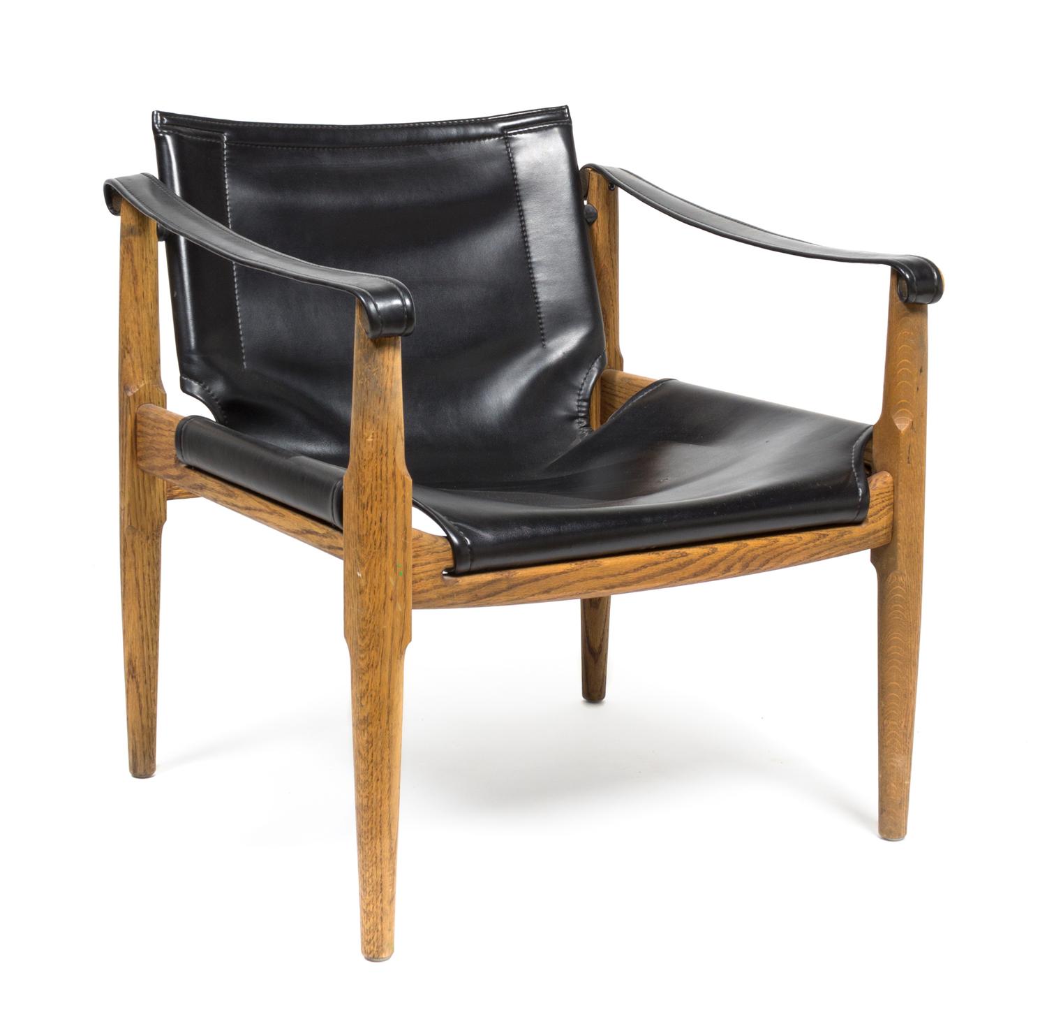 An Oak and Black Leather Safari Chair Height 27 1/2 x width 25 x depth 24 1/2 inches.