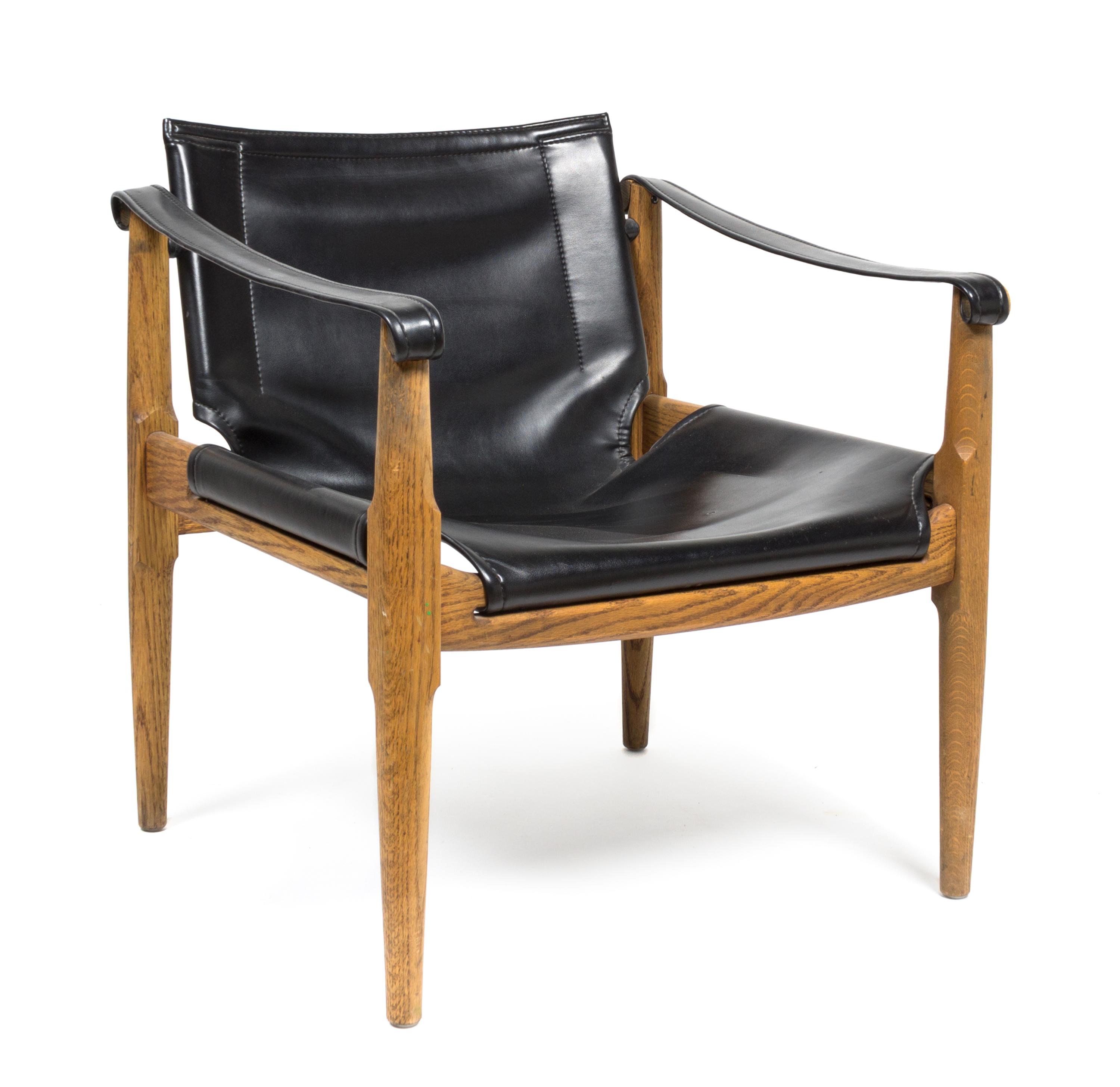 An Oak and Black Leather Safari Chair Height 27 1/2 x width 25 x depth 24 1/2 inches.