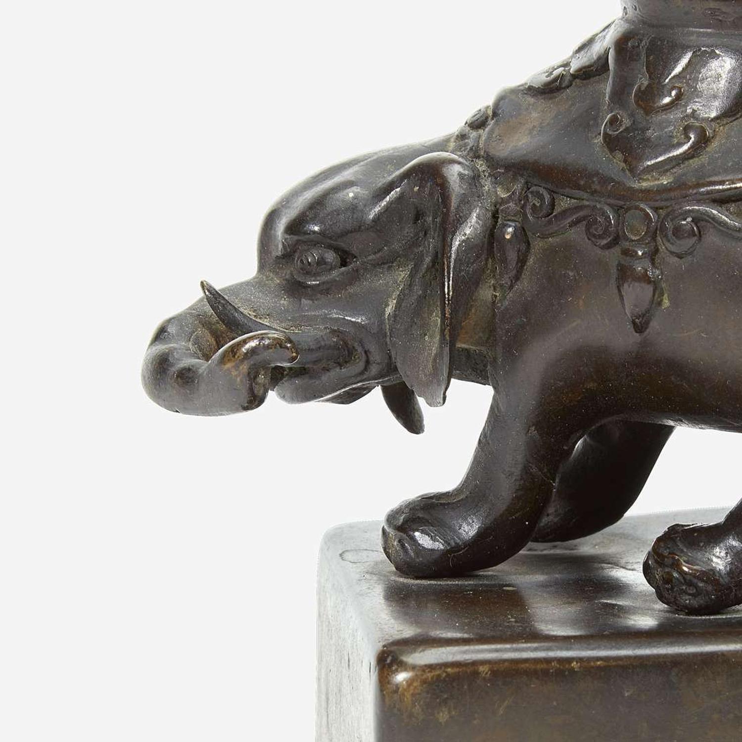 A pair of Japanese "Elephant and Dragon" patinated bronze openwork pricket candlesticks Edo period, 18th/early 19th Century