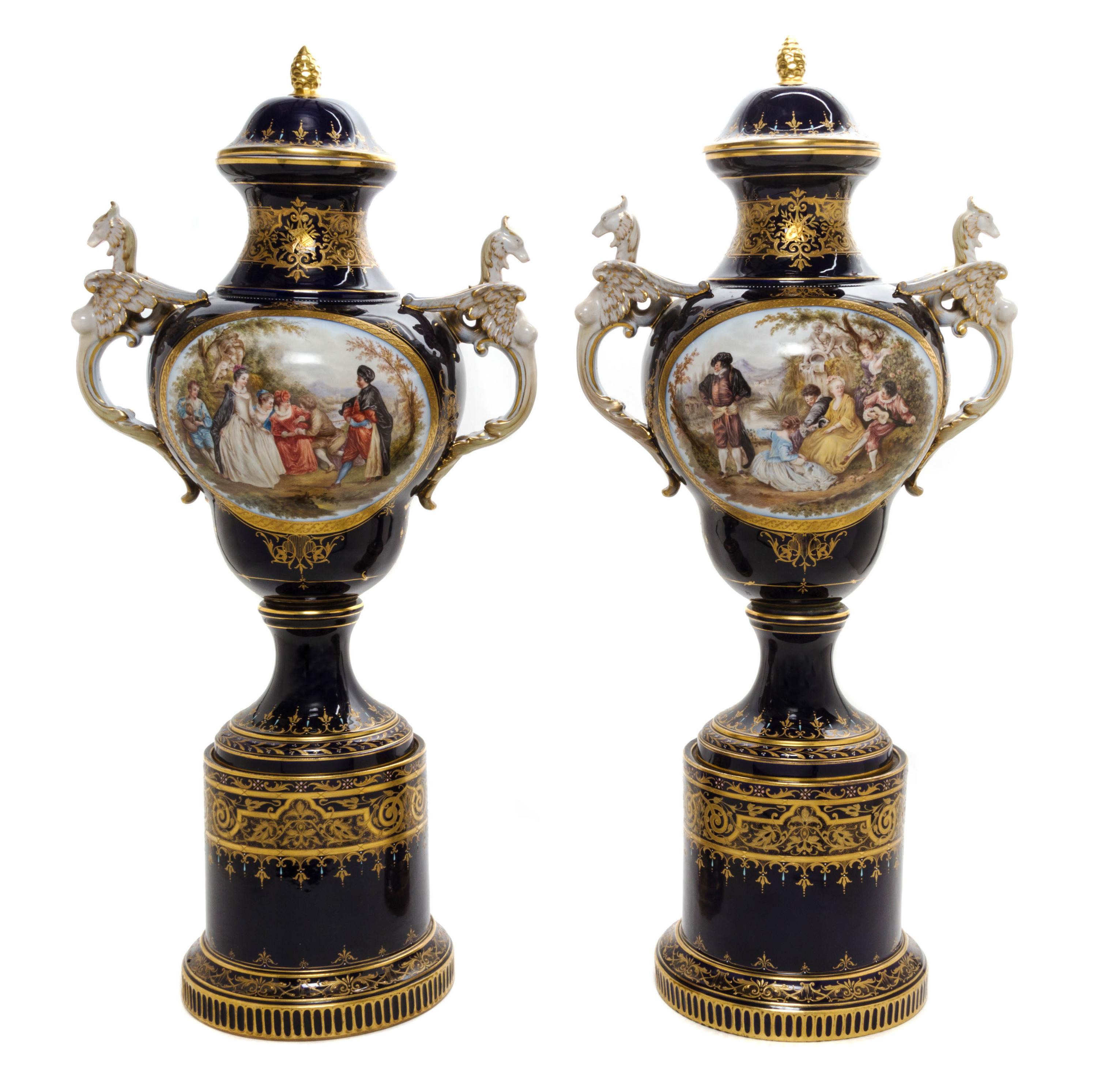 A Pair of Royal Vienna Porcelain Urns, Covers and Stands, Height overall 32 1/4 inches.