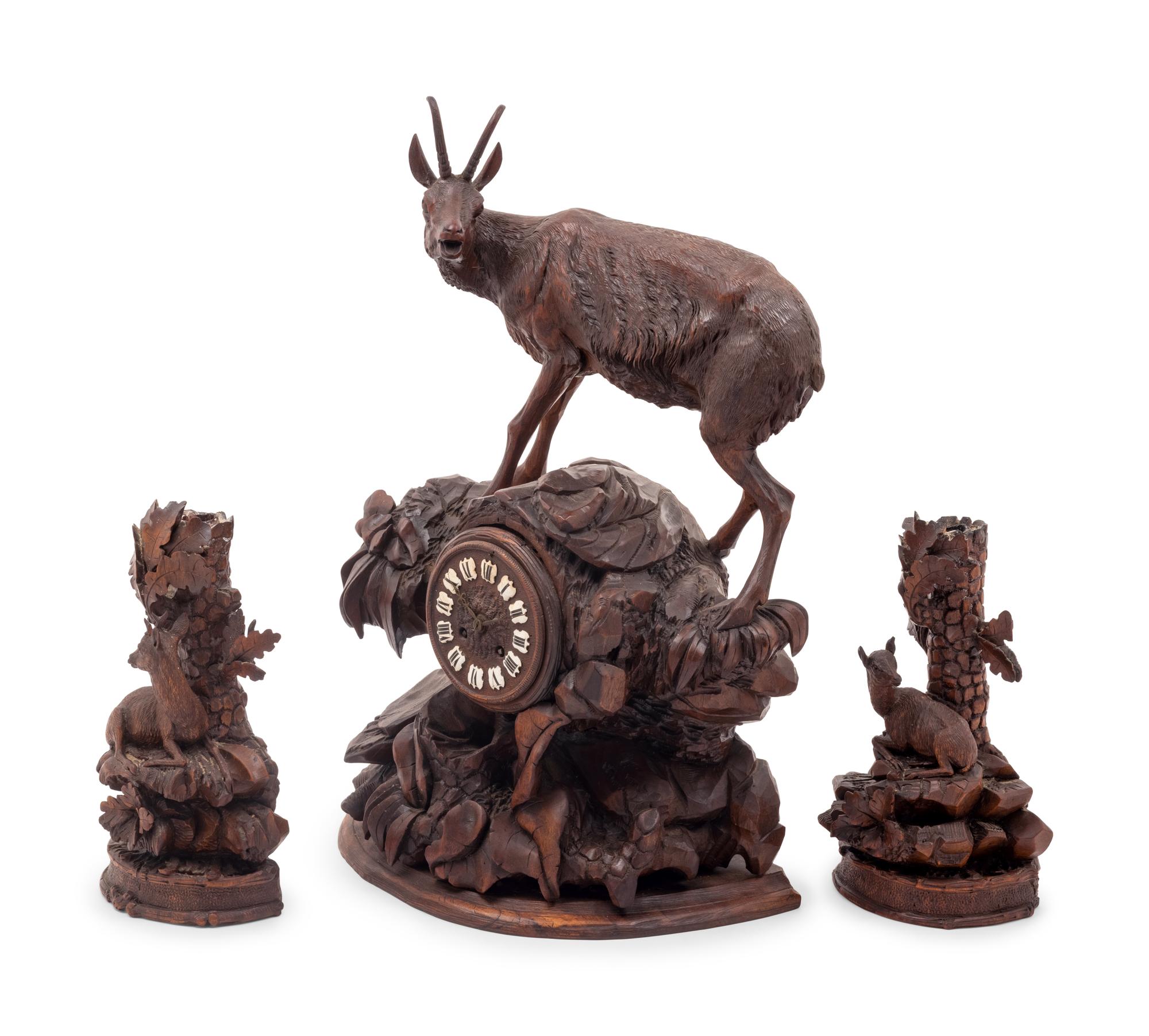 A Black Forest Carved Clock Garniture