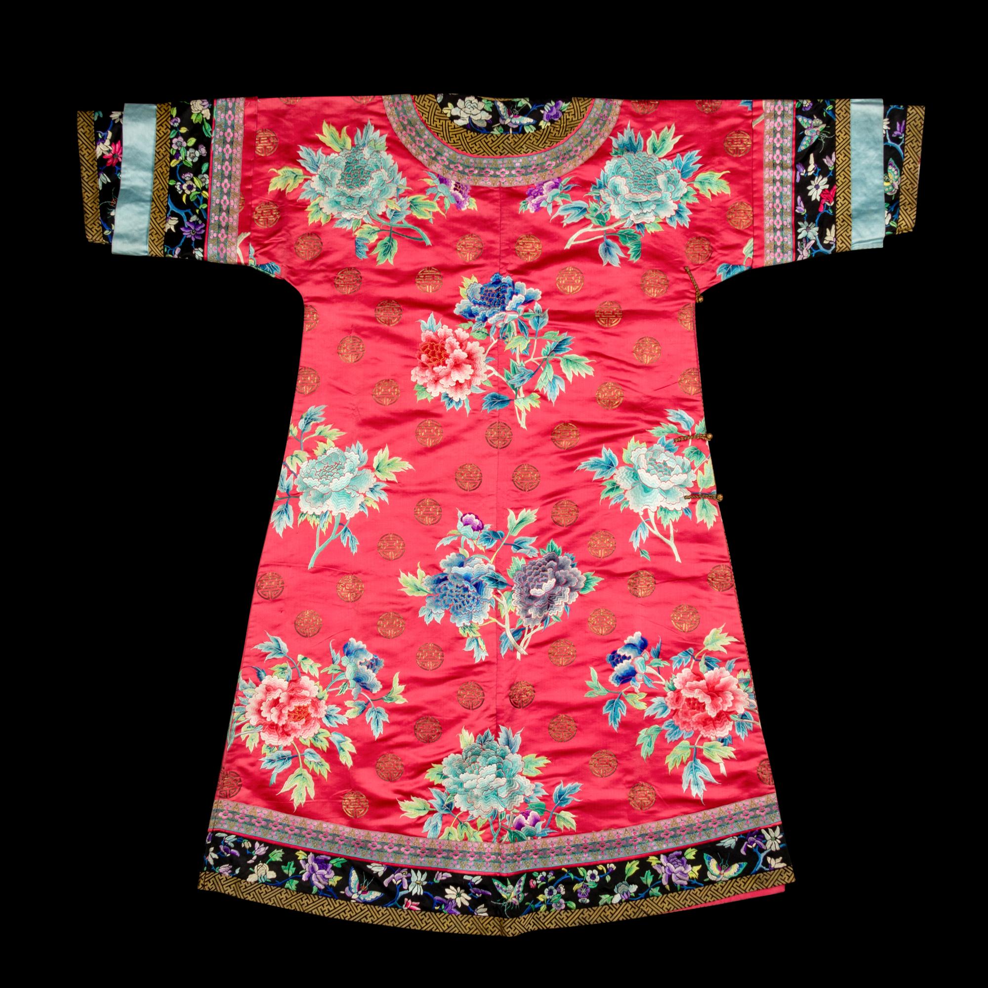 A Chinese Red Ground Embroidered Silk Manchu Lady's Informal Robe, Changyi, Late 19th Century 清晚期 桃紅緞綉牡丹團壽紋氅衣
