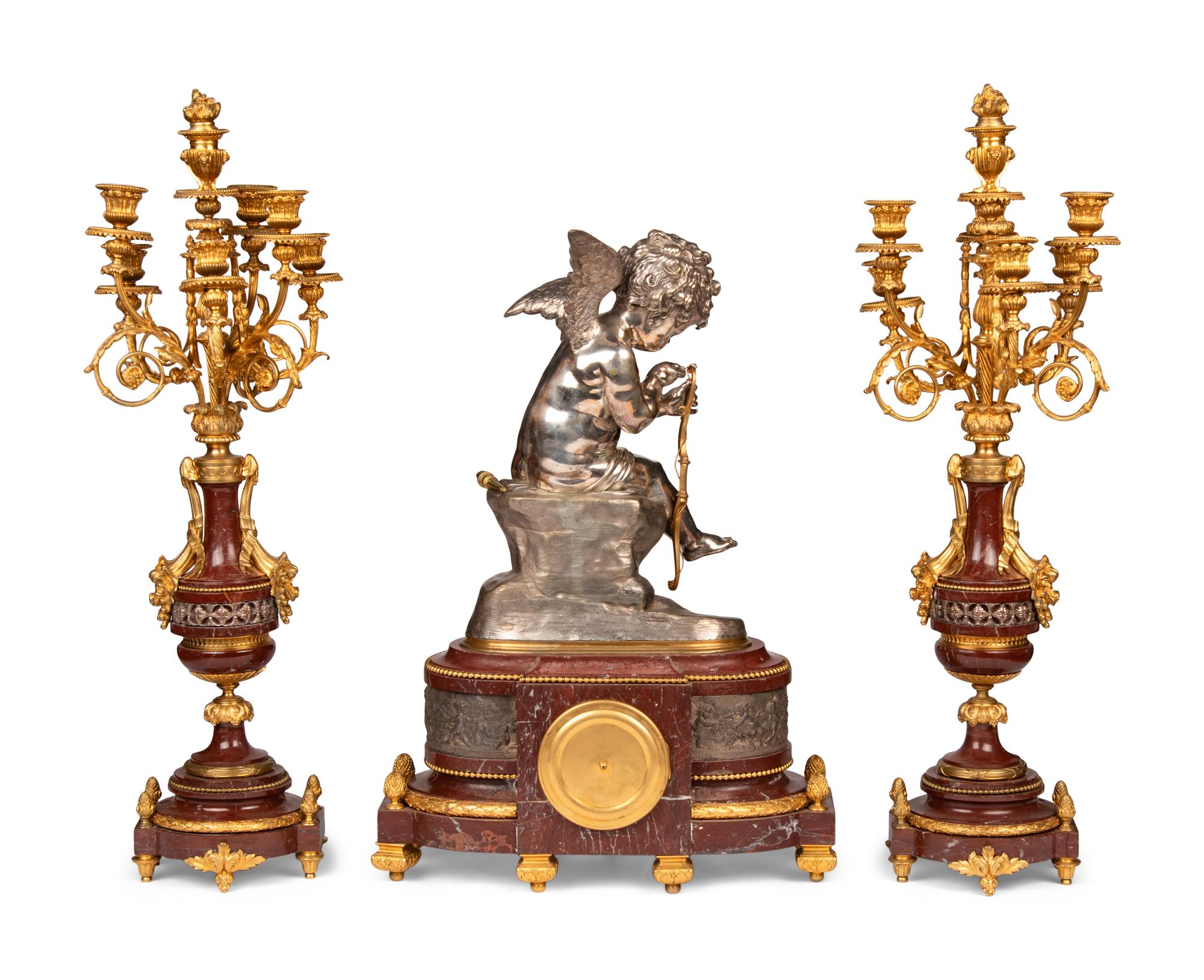 A French Gilt and Silvered Bronze and Rouge Marble Three-Piece Clock Garniture