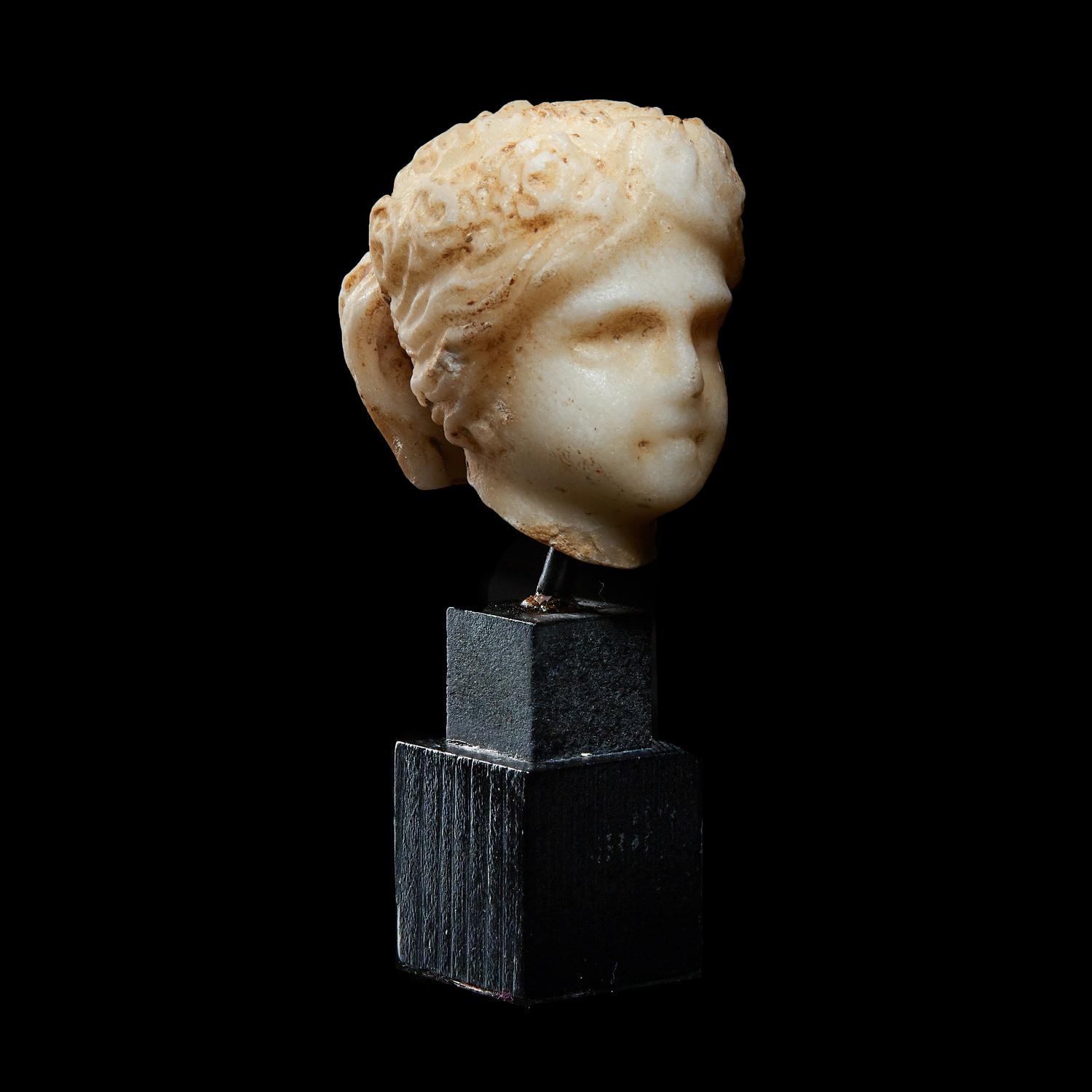 A Roman Marble Head of a Muse, Possibly Flora