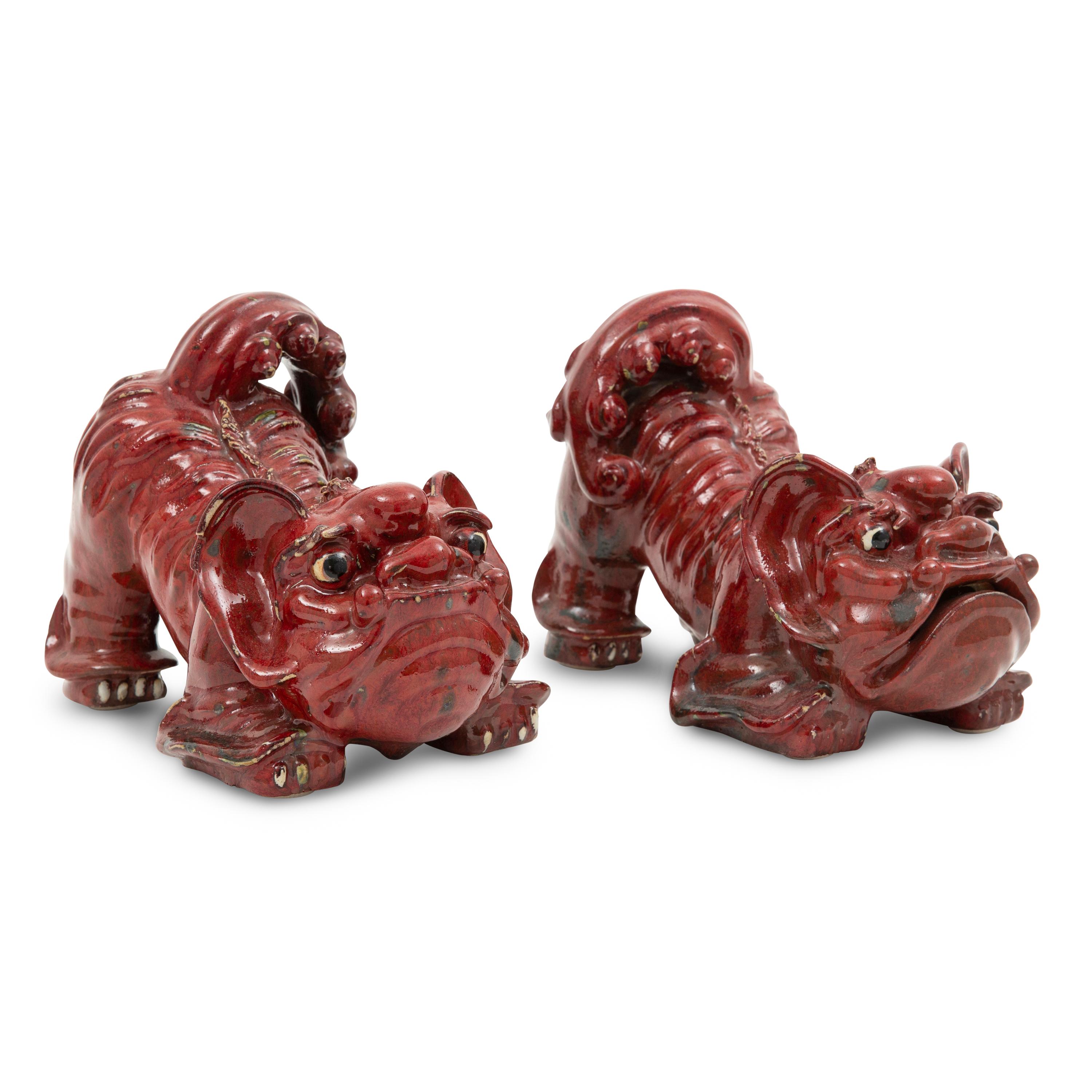 A Pair of Sang de Boeuf Glazed Earthenware Models of Guardian Lions