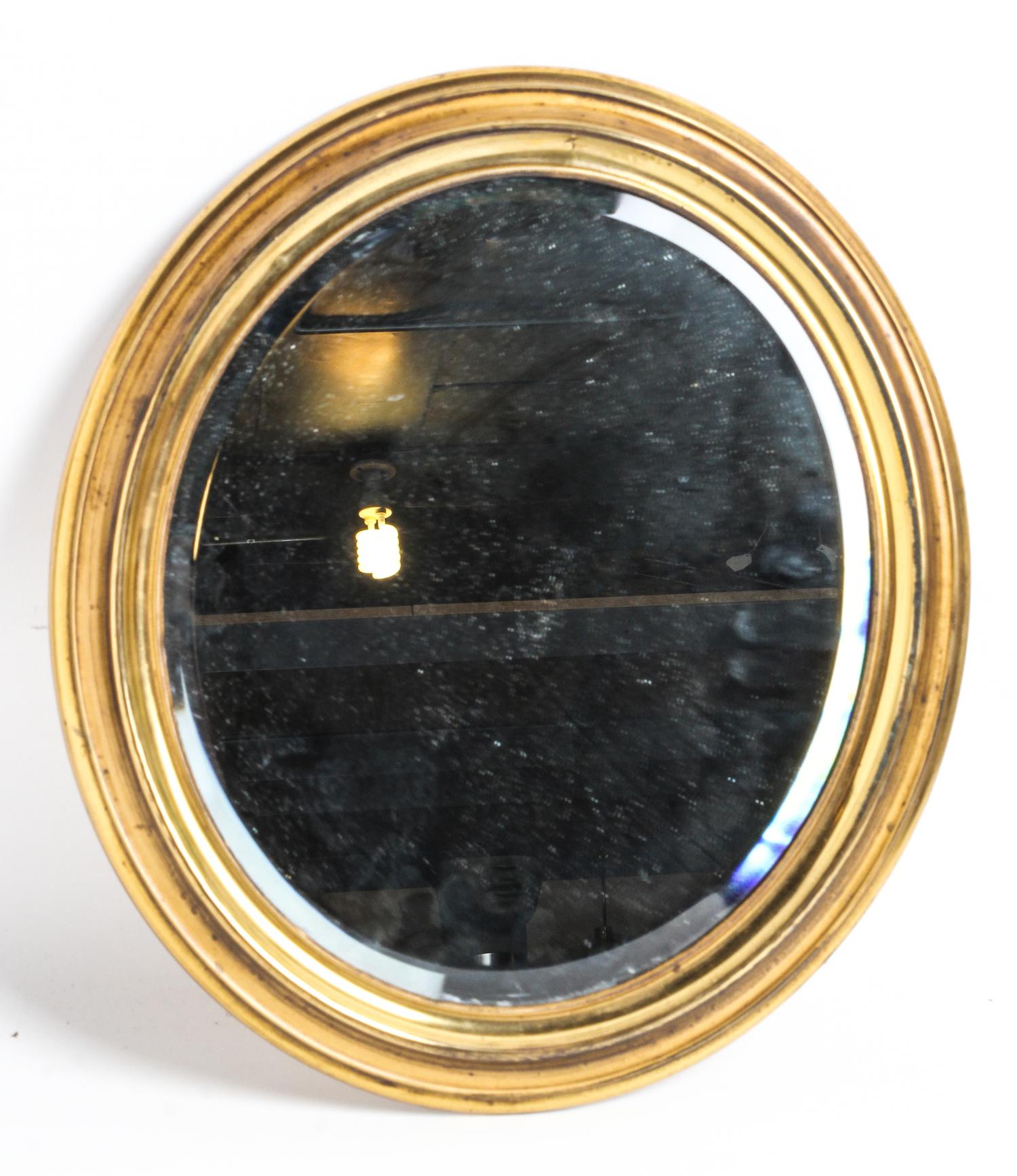 An Oval Gilt Metal Mirror Height 15 x width 13 inches.