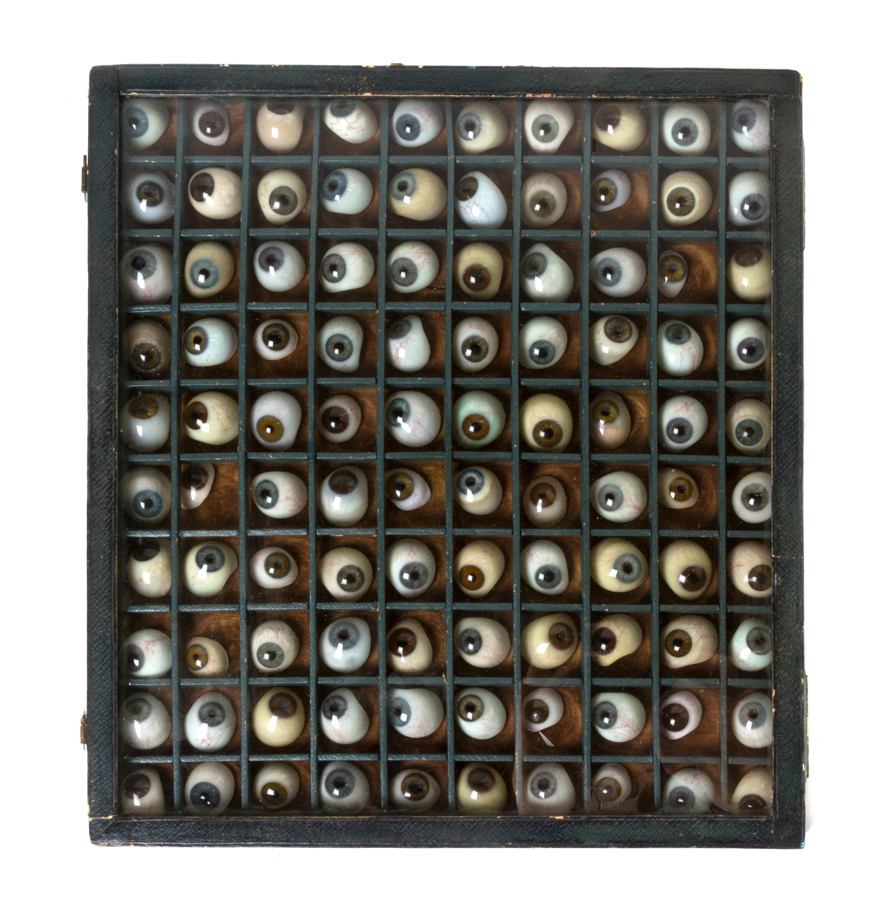 A Collection of Prosthetic Glass Eyes, Height of case 12 3/4 x width 11 5/8 inches.