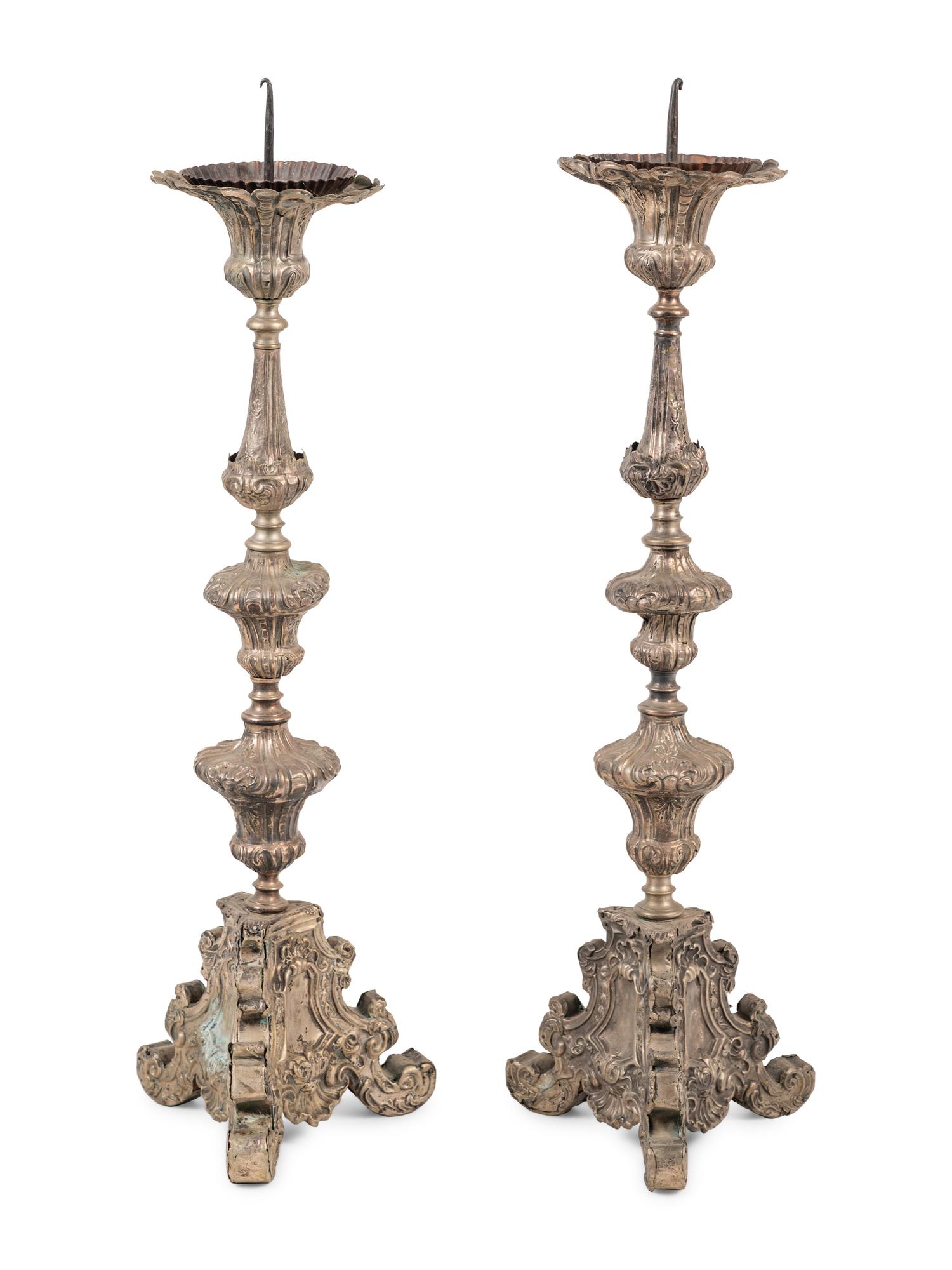 A Pair of Baroque Repoussé Decorated Silvered Metal Pricket Sticks