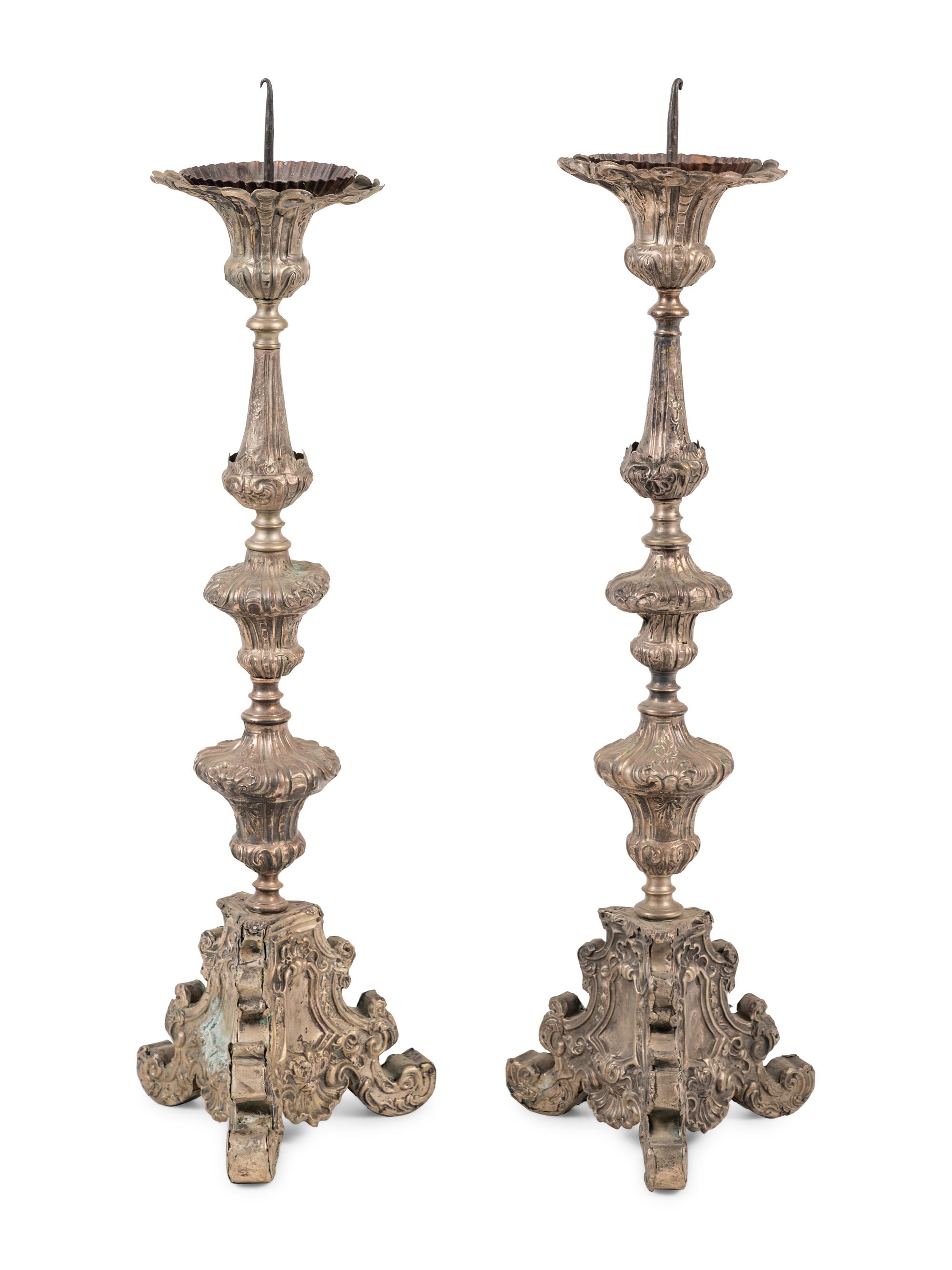 A Pair of Baroque Repoussé Decorated Silvered Metal Pricket Sticks