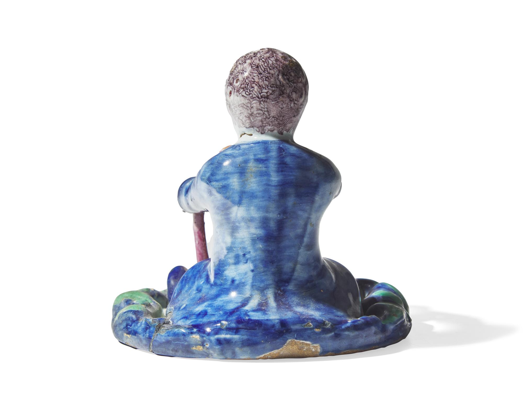 A small Dutch Delft figure of a boy holding birdcage with bird, 18th century