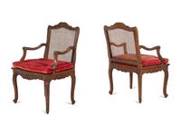 A Pair of Régence Style Carved Walnut and Caned Fauteuils à la Reine