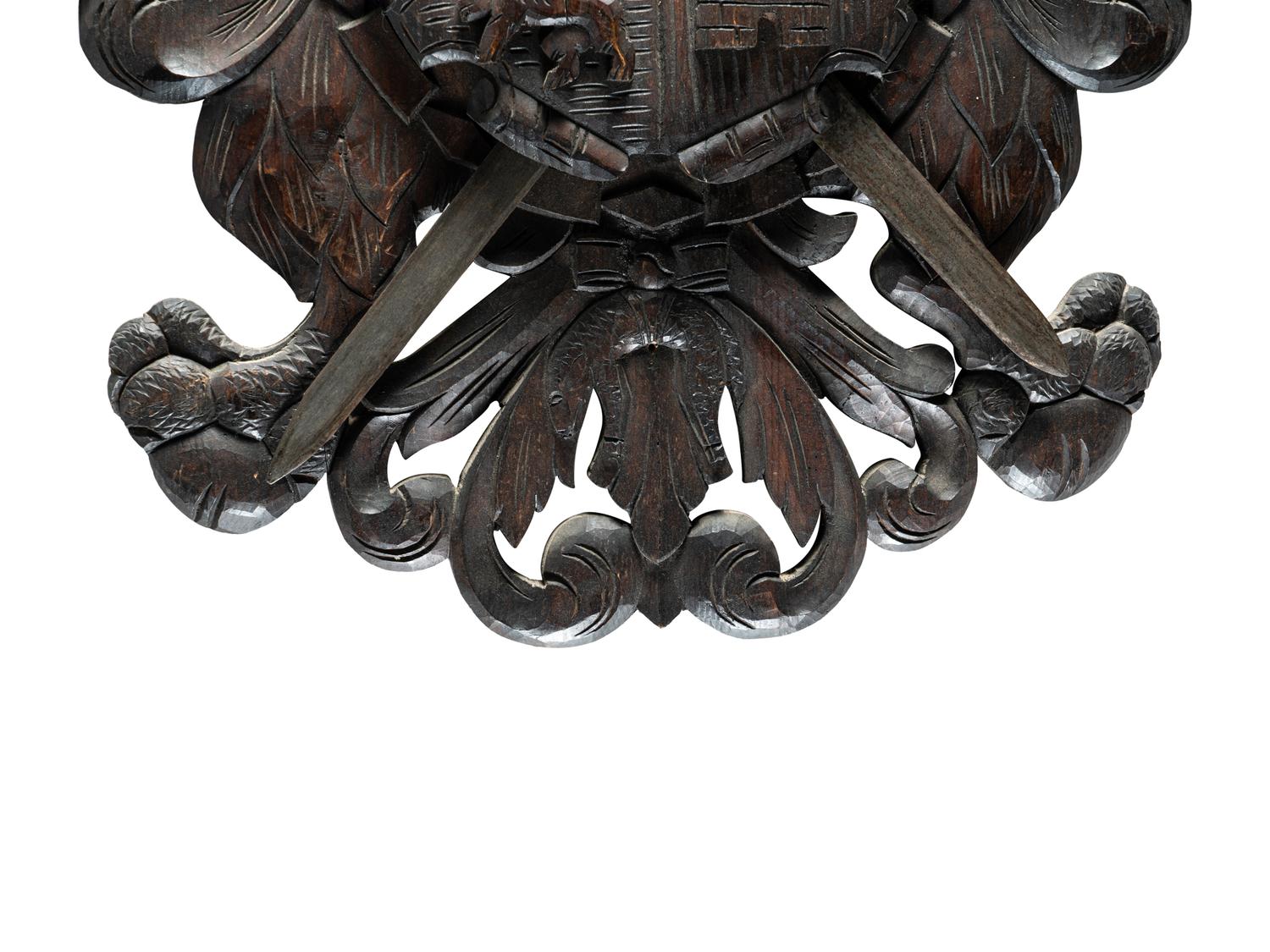 A Continental Carved Walnut Coat-of-Arms Plaque with Metal Crossed Swords