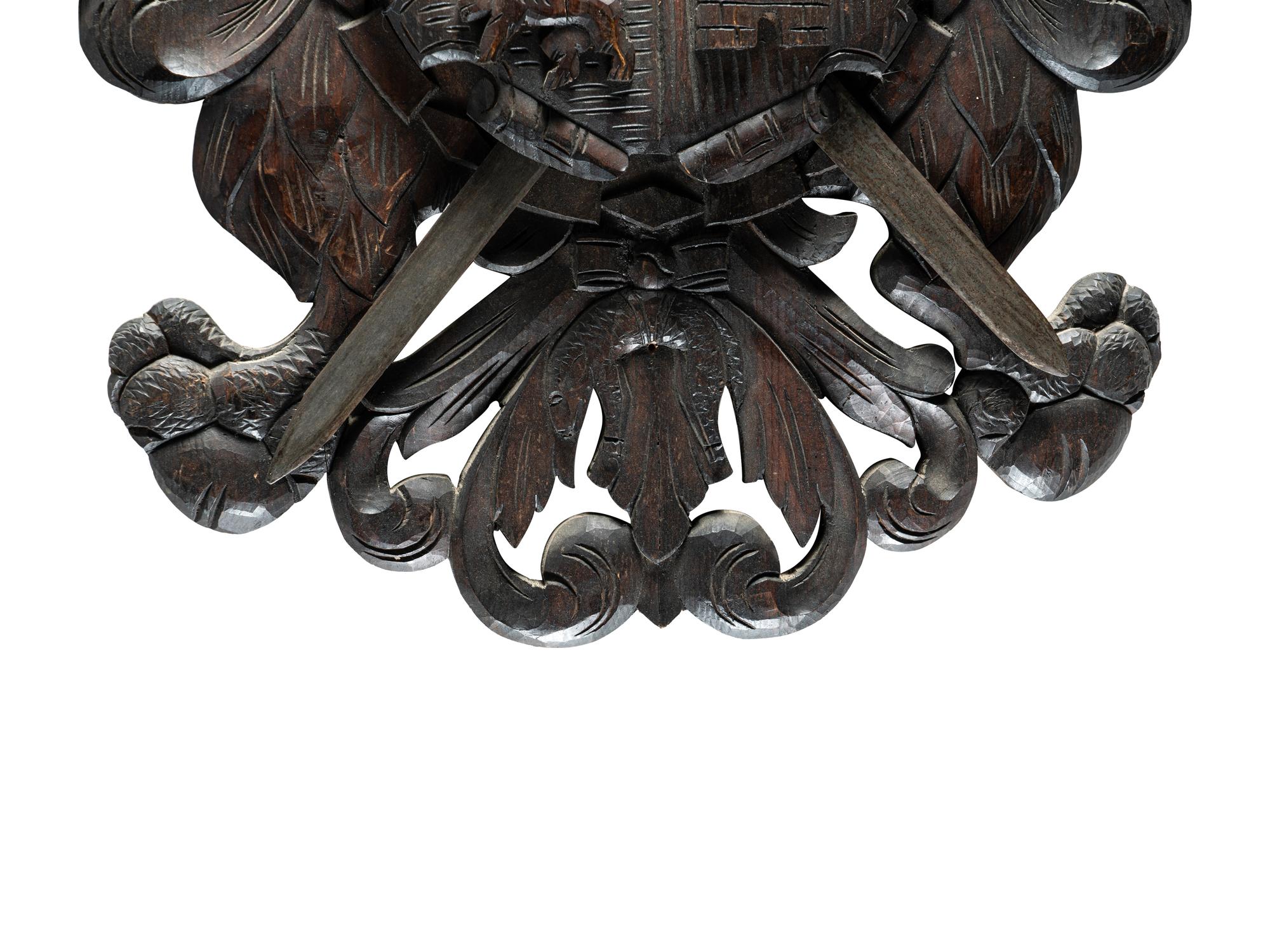 A Continental Carved Walnut Coat-of-Arms Plaque with Metal Crossed Swords