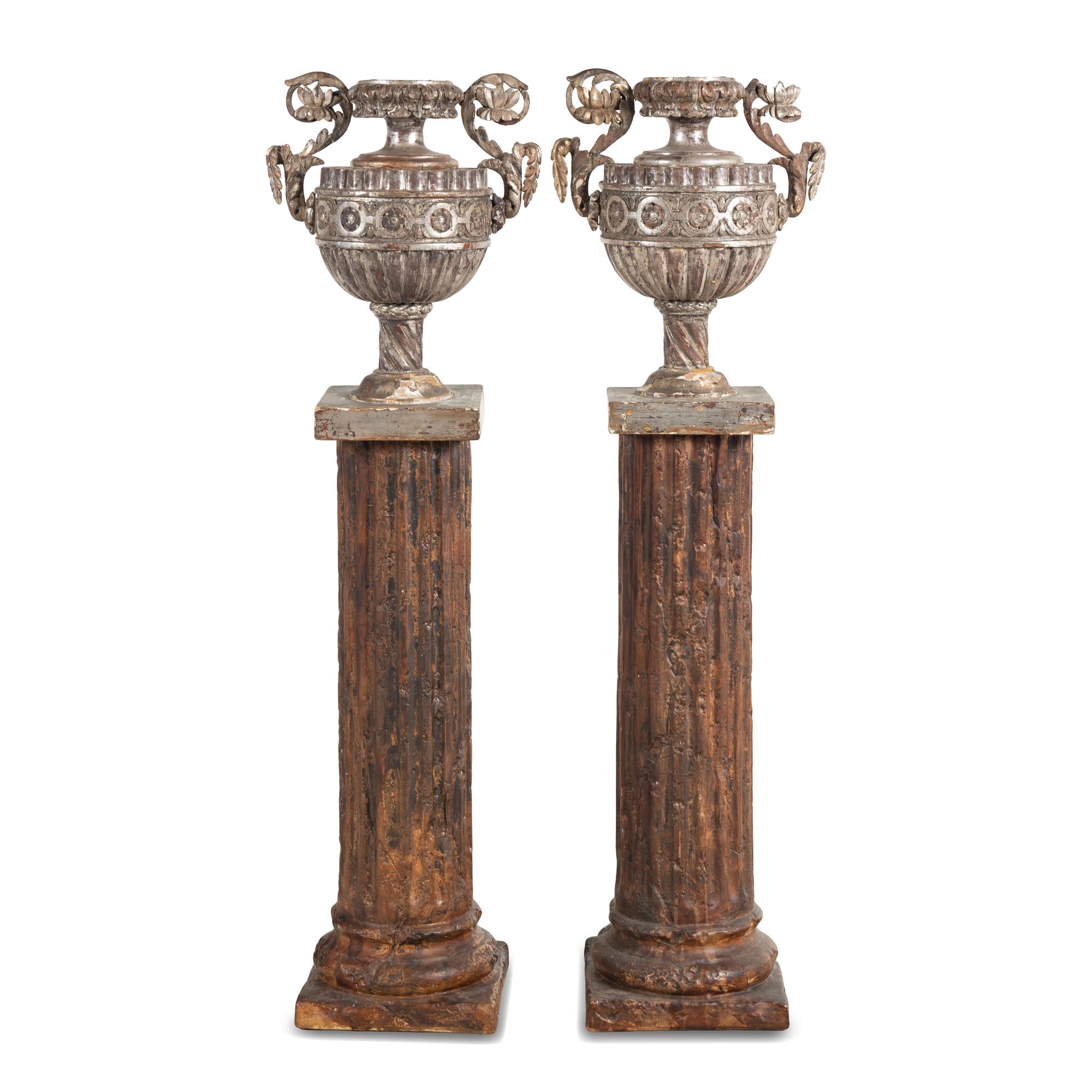 A Pair of Silvered Wood Urn-Form Finials on Painted Columnar Pedestals