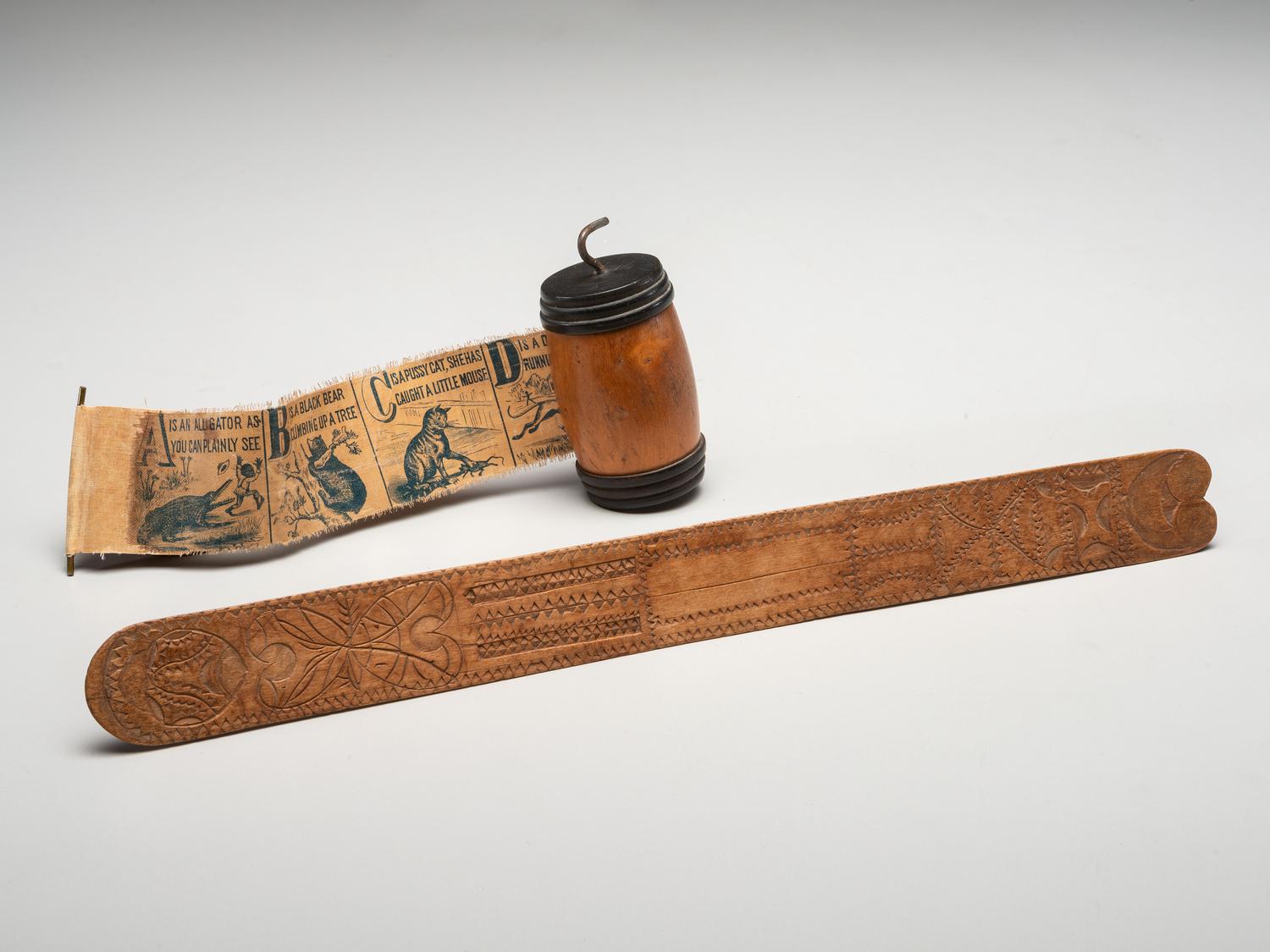 A Carved Fruitwood Busk and a Child's Alphabet What-not