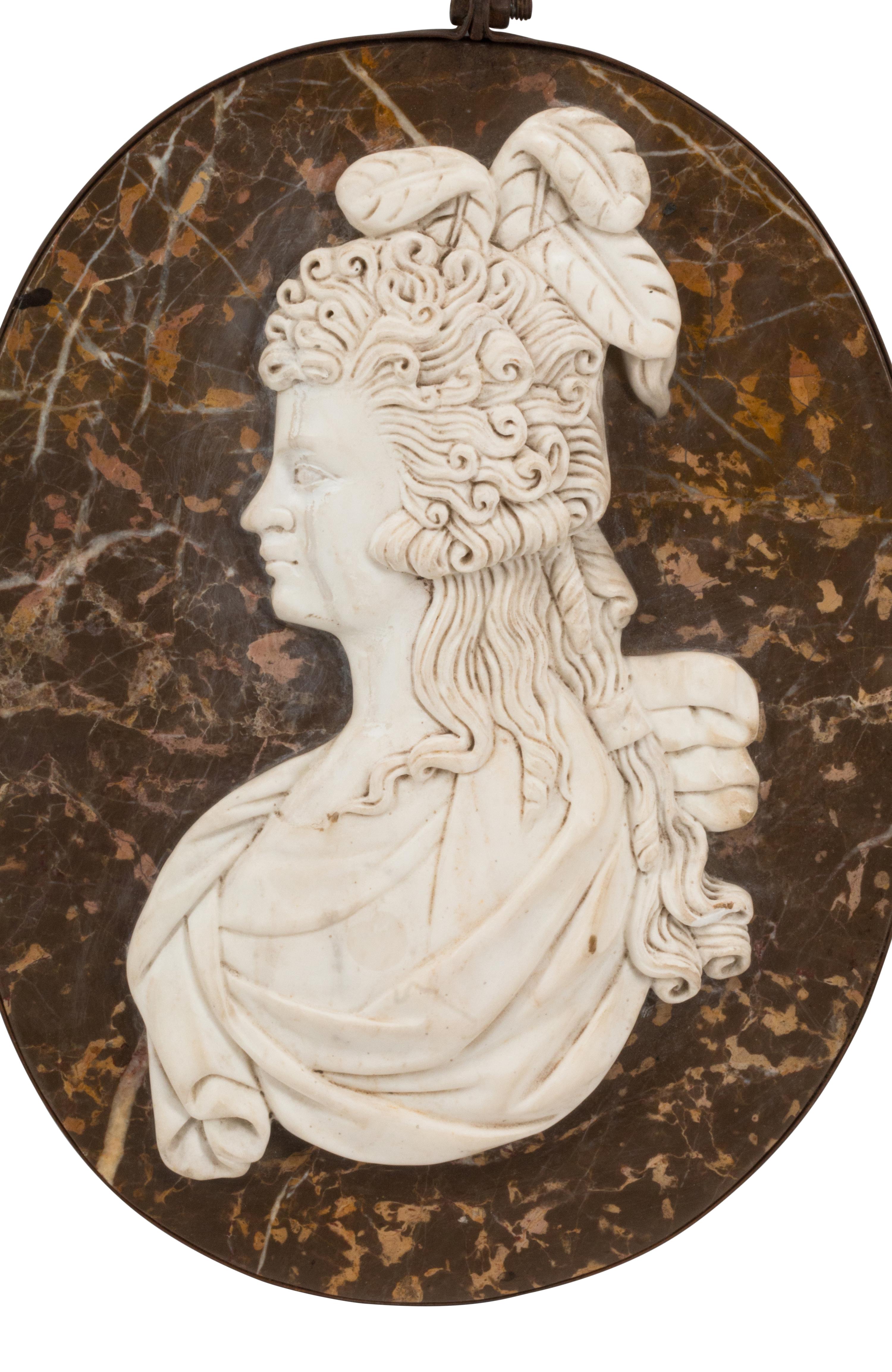 A Set of Four Italian Carved Marble and Iron Mounted Profile Medallions