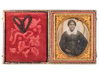 [EARLY PHOTOGRAPHY-AFRICAN AMERICANA]. Sixth plate daguerreotype portrait of subject identified as "Grandma Binx" with braided hairwork heart.