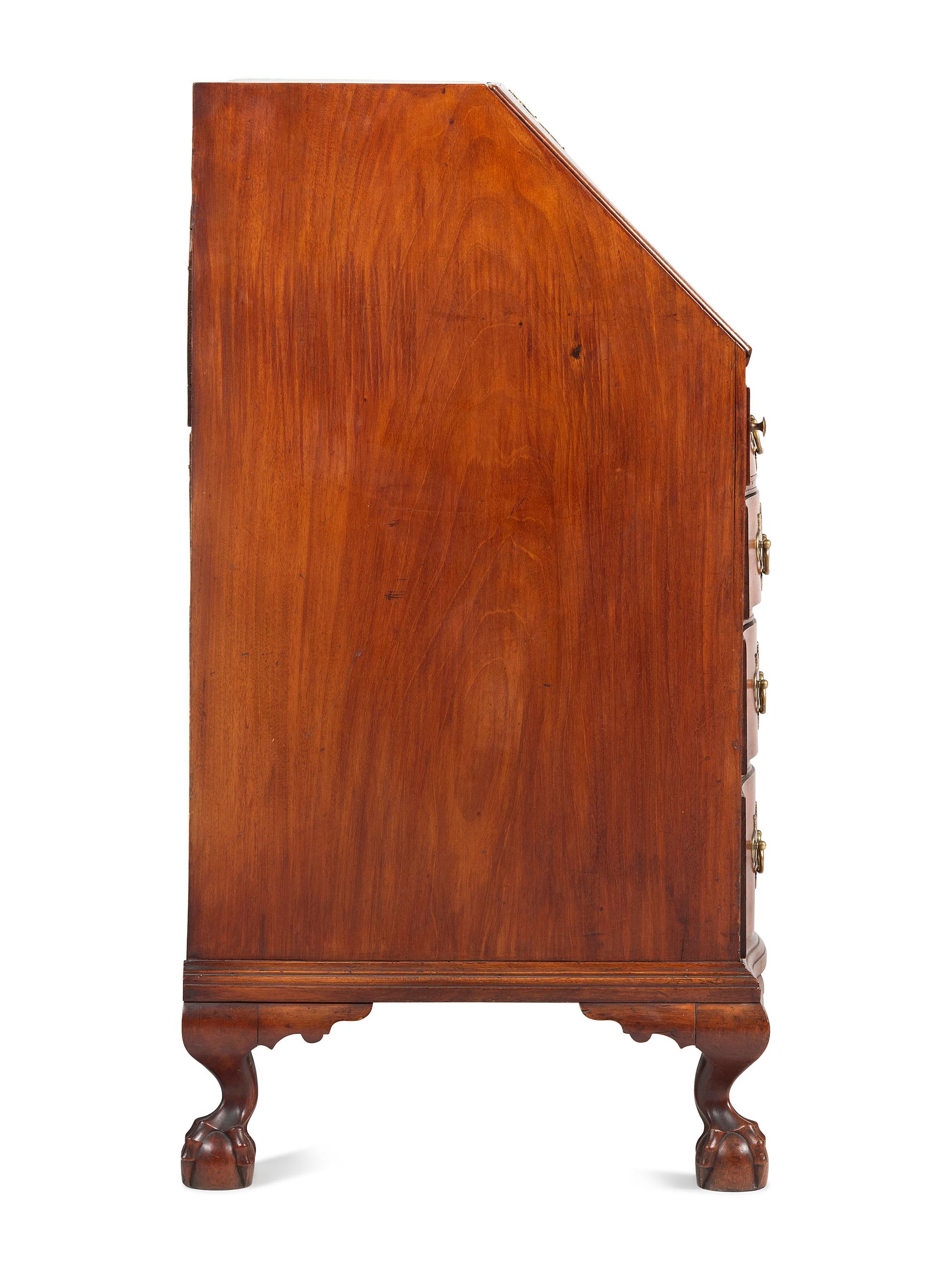 A Chippendale Carved and Figured Mahogany Reverse-Serpentine Claw-and-Ball Foot Slant-Front Desk