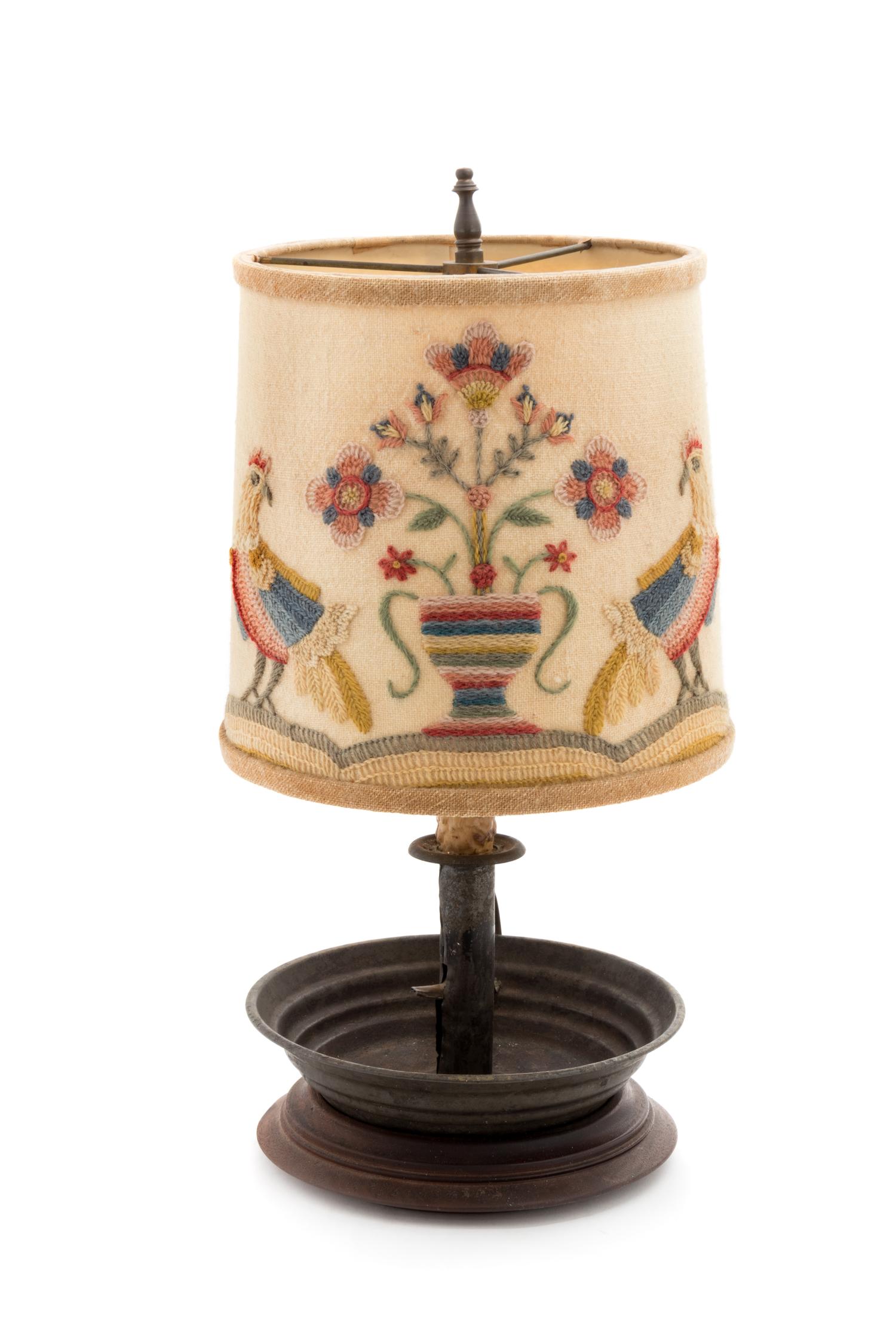 A Primitive Metal Candlestick with a Later Crewel Work Shade