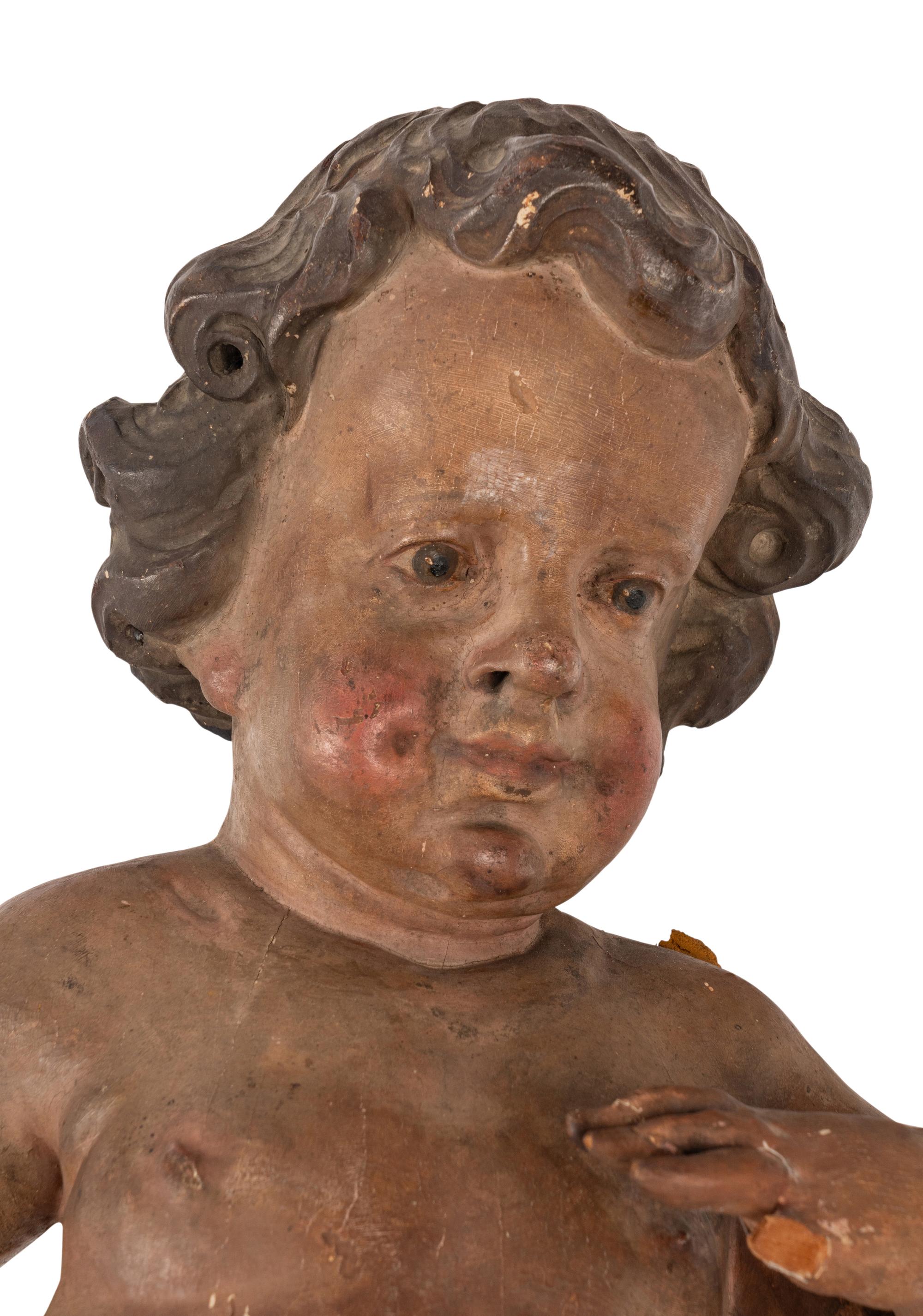 A Painted and Parcel Gilt Wood Figure of a Putto