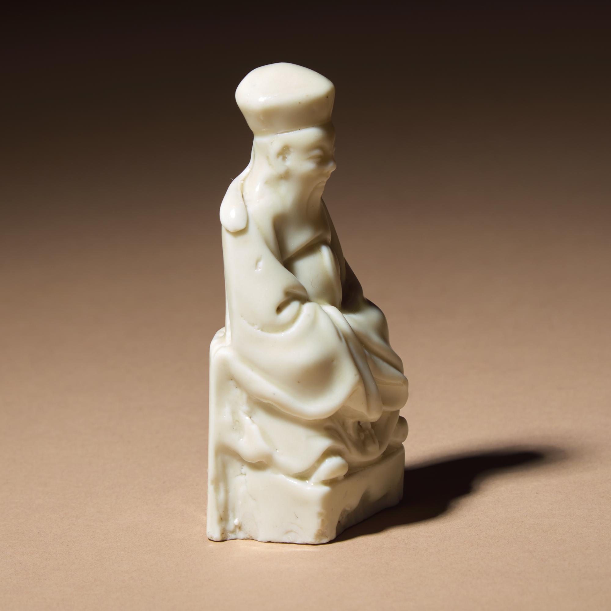A Chinese Blanc-de-Chine Porcelain Seated Figure of a Dignitary, 17th Century — 清早期 德化白瓷文官坐像