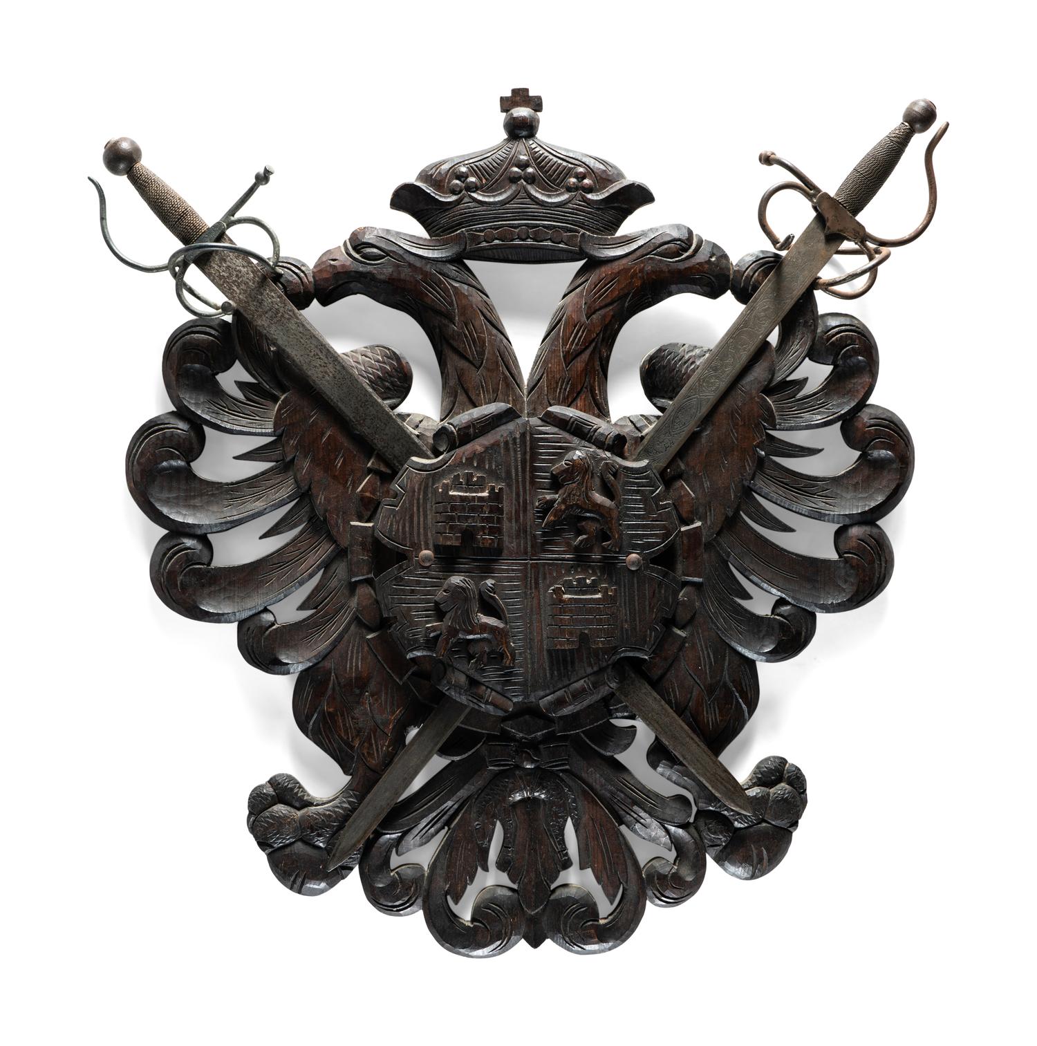 A Continental Carved Walnut Coat-of-Arms Plaque with Metal Crossed Swords