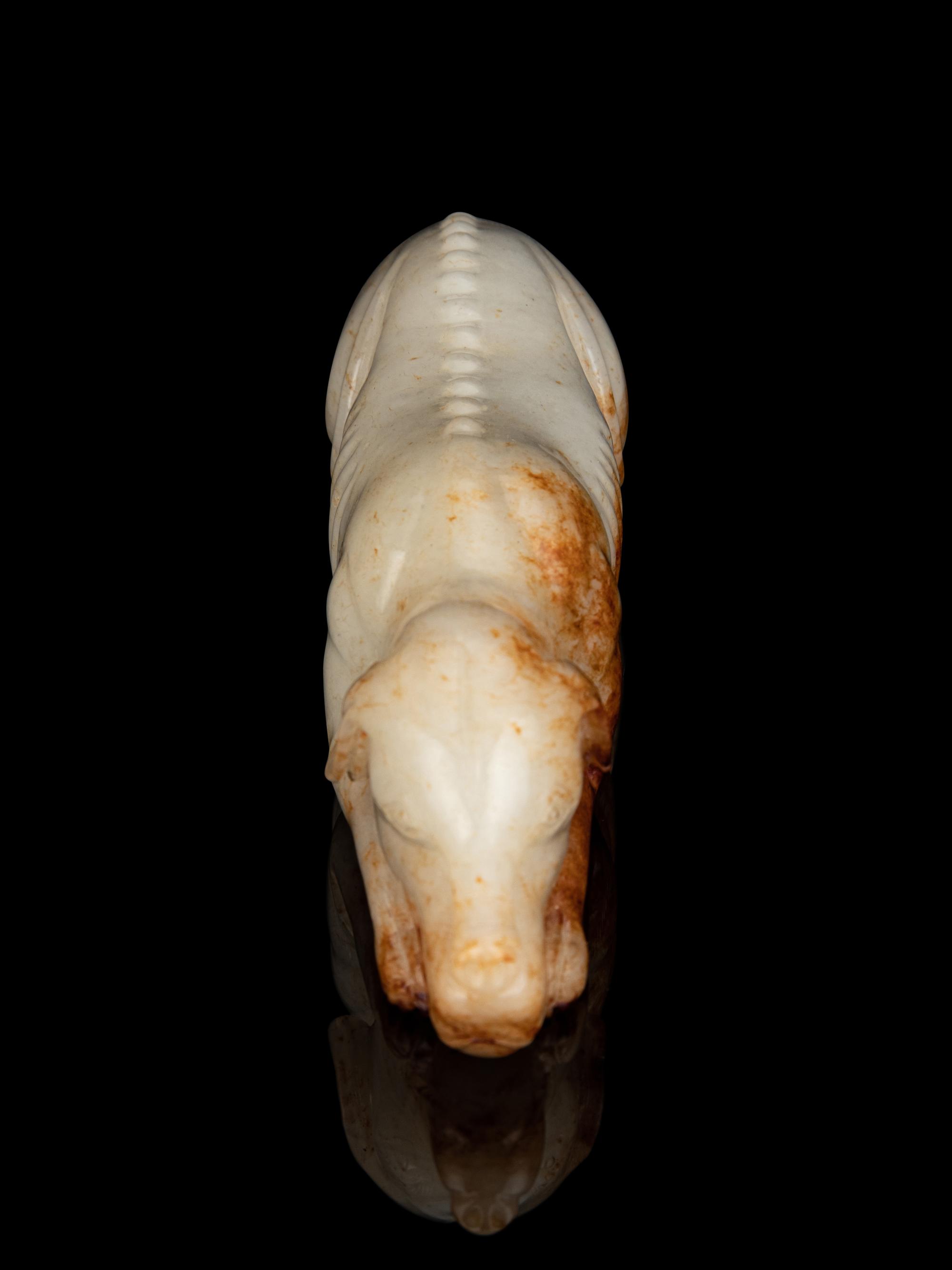 A White and Russet Jade Figure of a Recumbent Dog