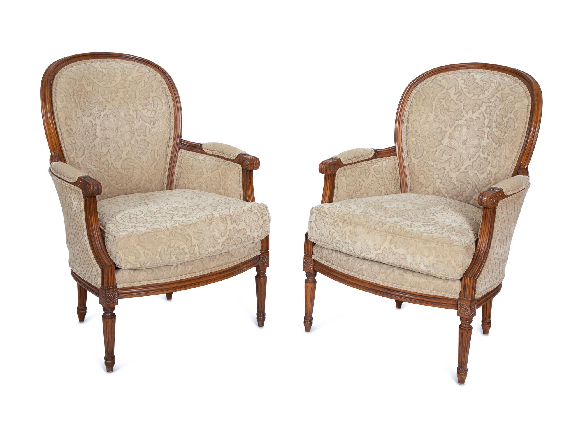 A Pair of Louis XVI Style Carved Walnut Bergères