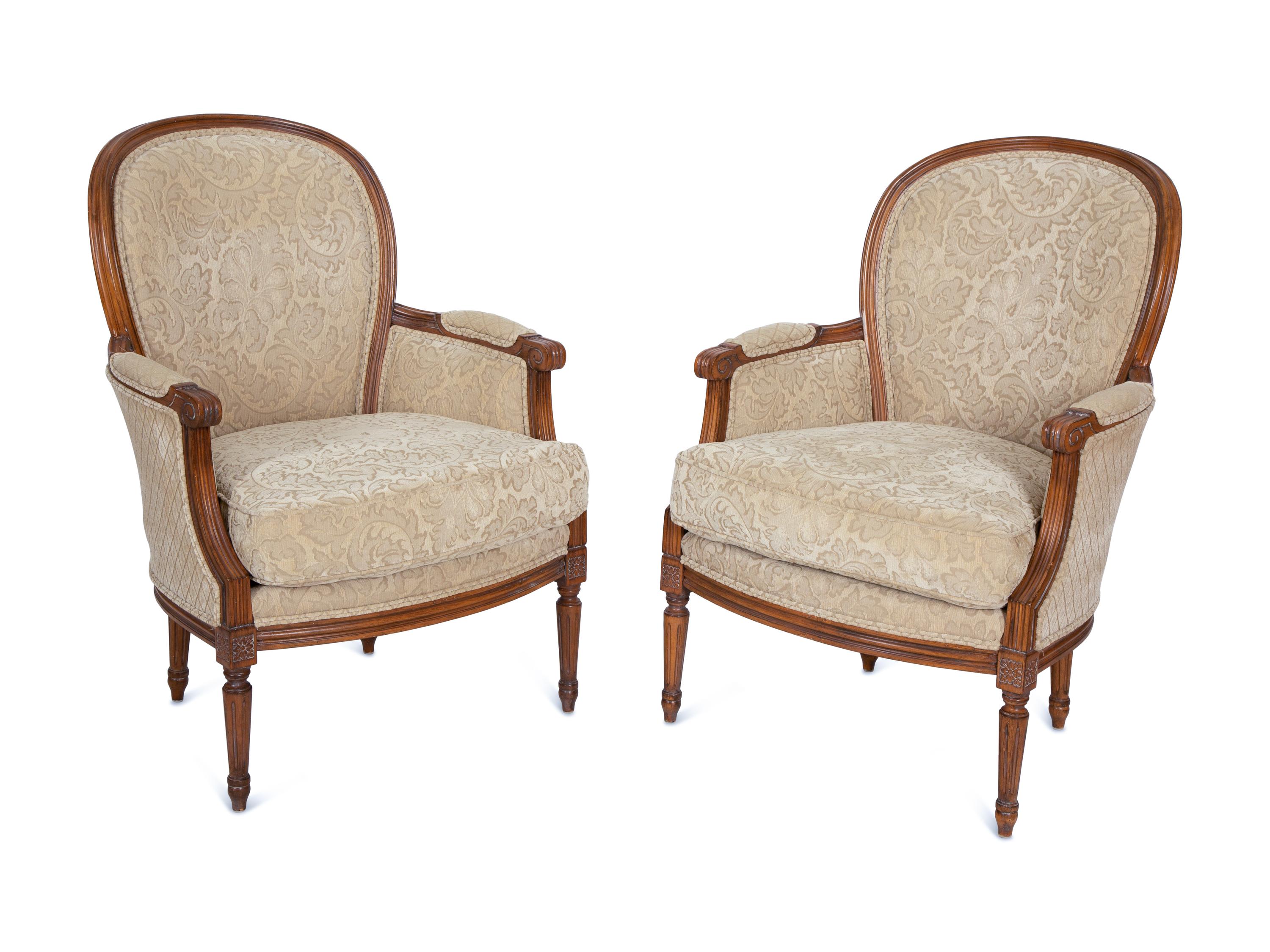 A Pair of Louis XVI Style Carved Walnut Bergères
