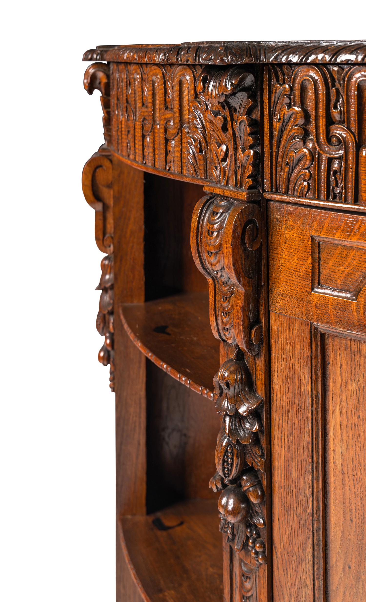 A Continental Carved Oak Demilune Cabinet