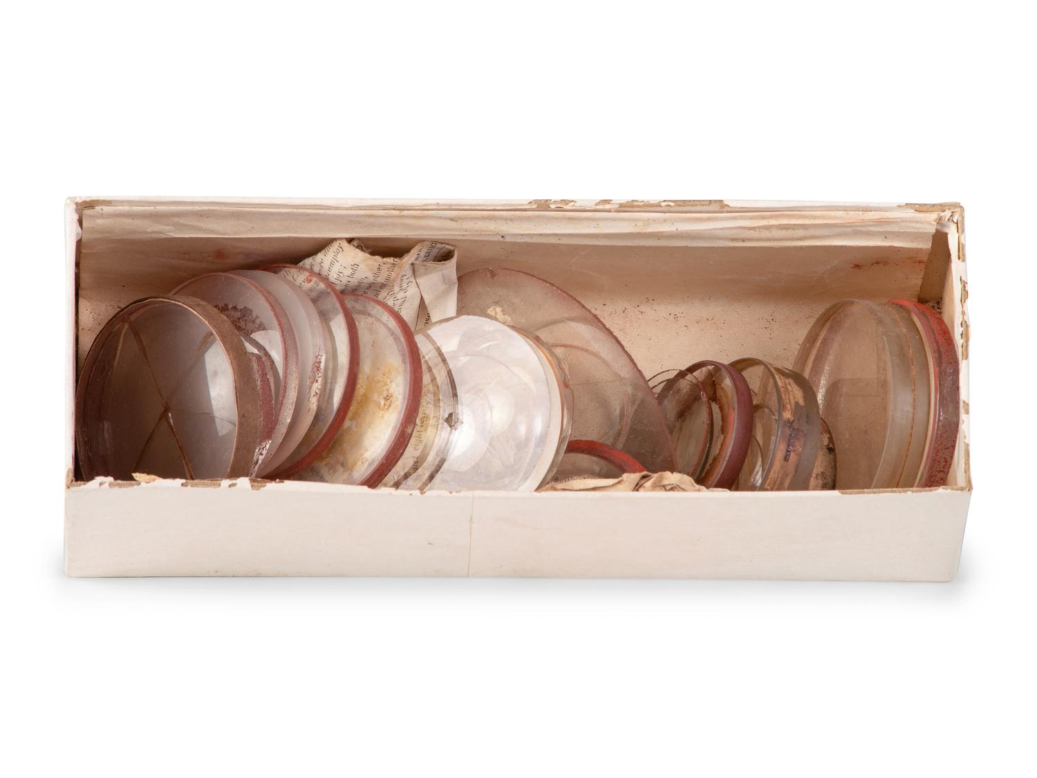 A collection of lenses and glass samples with manuscript notes addressed to Henry Fitz, New York, found in the workshop of George W. Fitz, Peconic, New York.