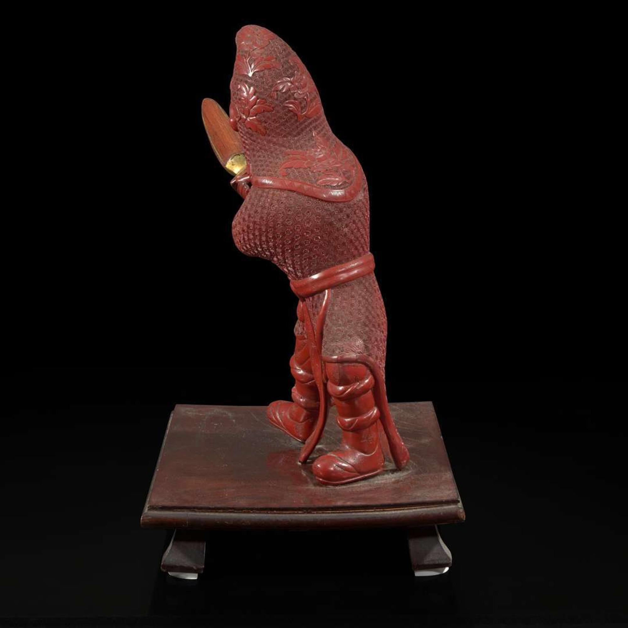 An unusual and finely-carved cinnabar lacquer figure of a warrior 朱漆武士像