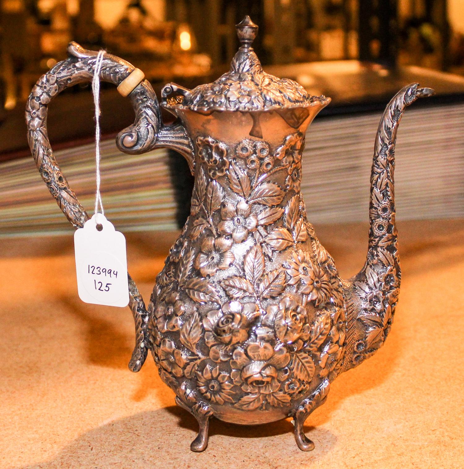 An American Silver Teapot, Baltimore Silversmiths Mfg. Co., having an urn finial, the body decorated with floral and foliate repousse d