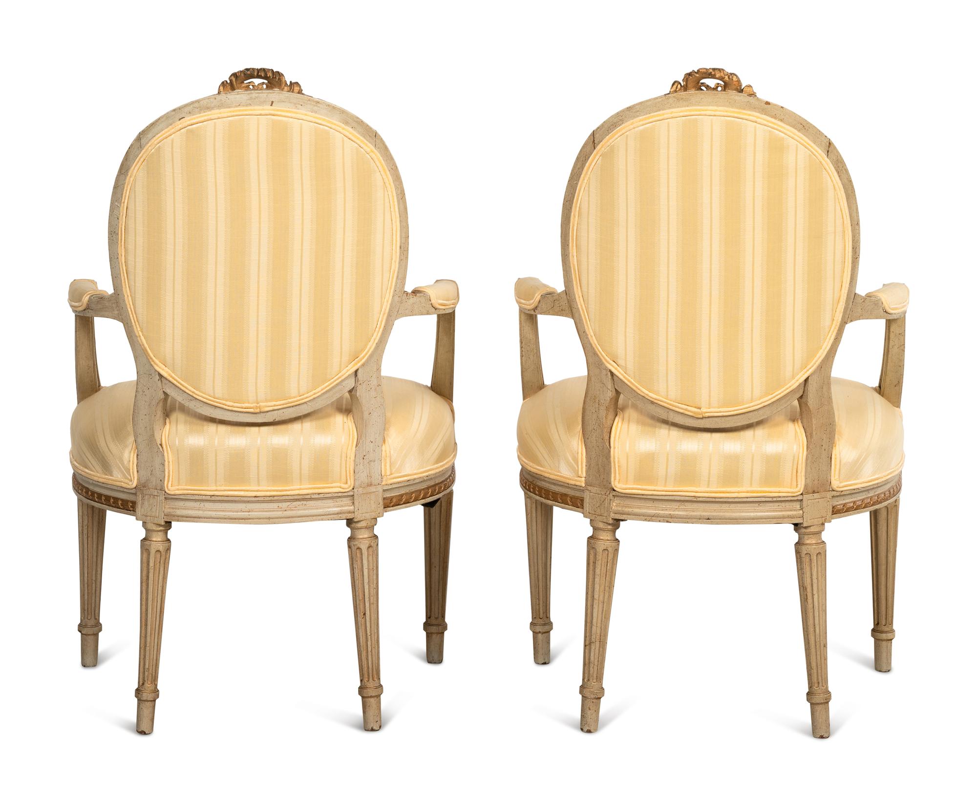 A Pair of Louis XVI Style Parcel Gilt and White Painted Fauteuils