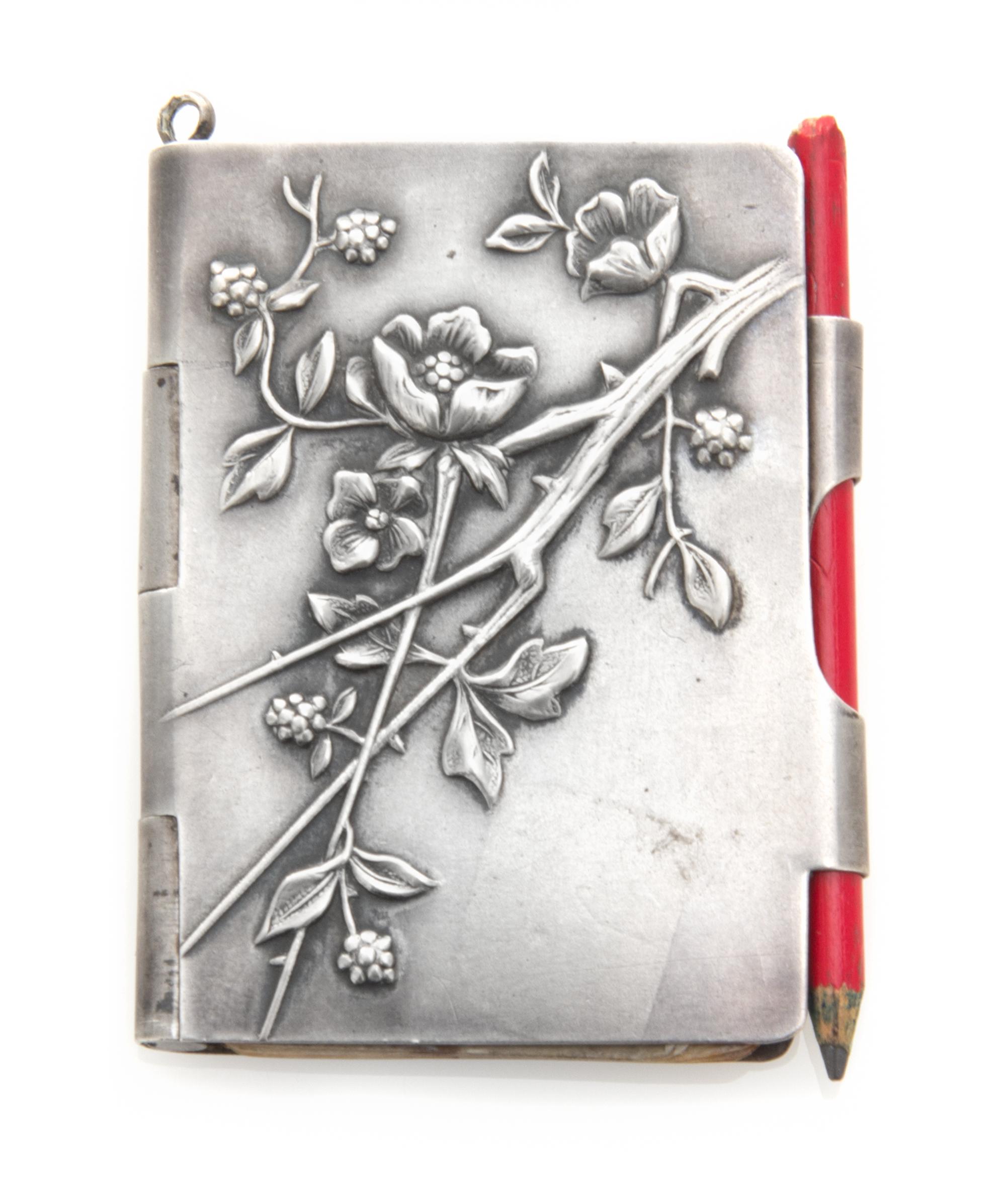 A Continental Silver Chatelaine Notepad, , the case worked to show flowering branches and opening to a partial sheet of stamp-cut paper